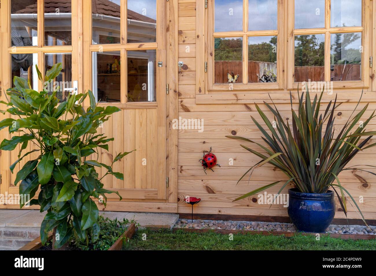 CASA ESTIVA O CAPANNA DI TRONCHI CON INSETTI ORNAMENTALI DECORATIVI E PIANTE Foto Stock