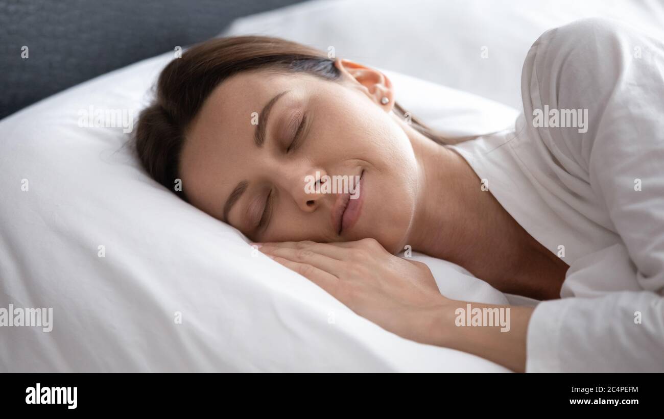 Calma giovane donna dormire rilassante in camera da letto Foto Stock