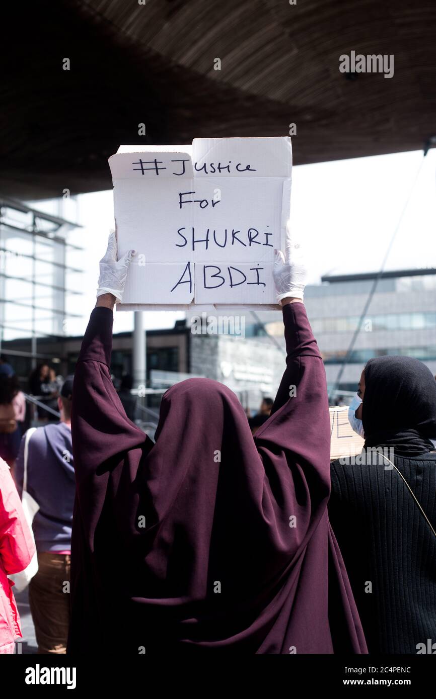 REGNO UNITO, GALLES. 27 Giugno 2020. I cittadini di Cardiff si riuniscono sotto la pioggia al Senedd (edificio dell'Assemblea Nazionale), nella baia di Cardiff, in solidarietà e per chiedere giustizia a Shukri Abdi, una giovane ragazza che è morta per mano di bullismo, come parte del movimento Black Lives Matter (BLM). Foto Stock