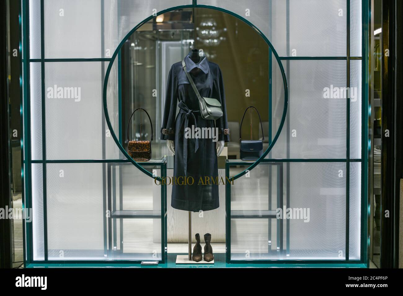 Milano - 13 gennaio 2020: Cappotto blu marino in una vetrina Giorgio Armani di notte Foto Stock