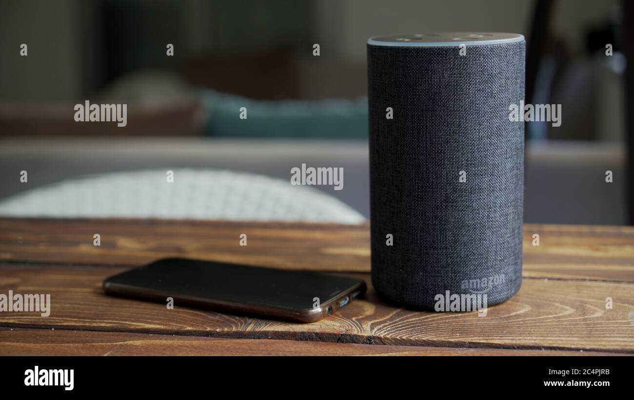 Grigio scuro Amazon Alexa Echo nero e smartphone sul tavolo di legno in un  soggiorno Foto stock - Alamy