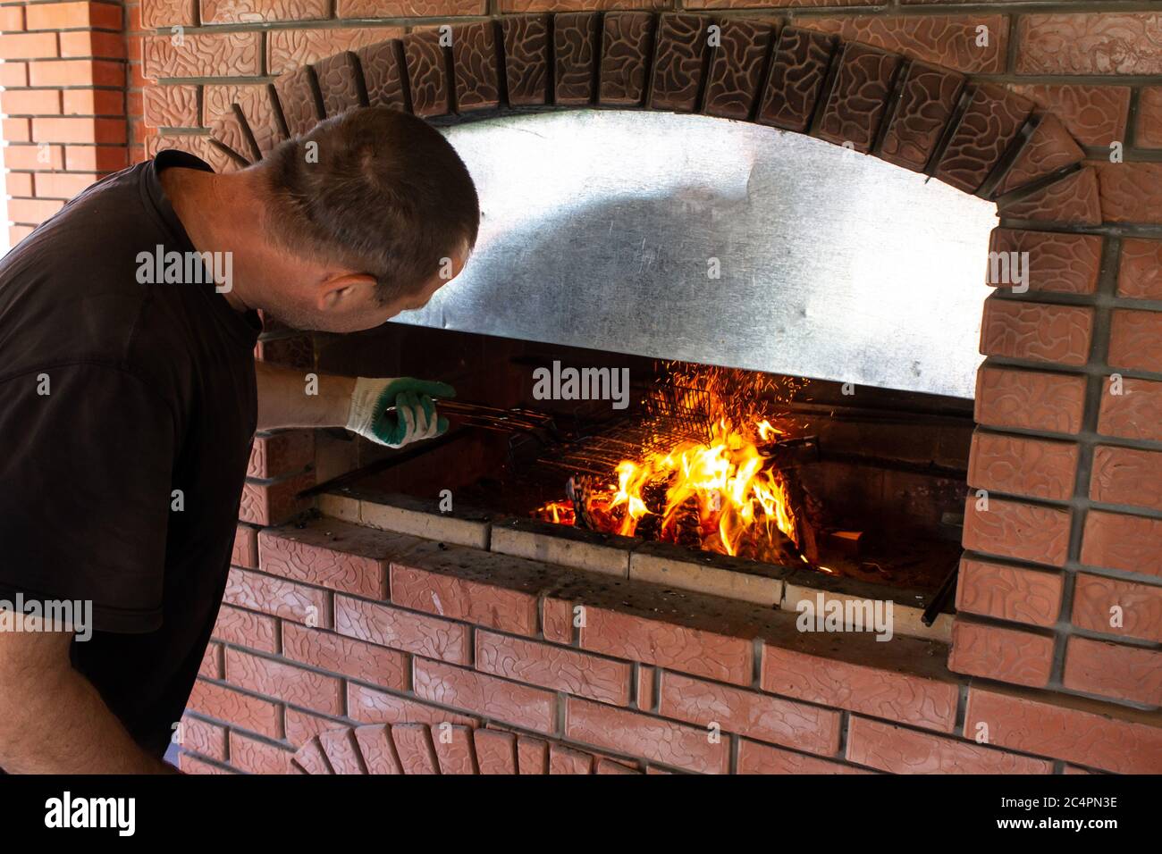 l'uomo arrosti barbecue vicino alla stufa Foto Stock