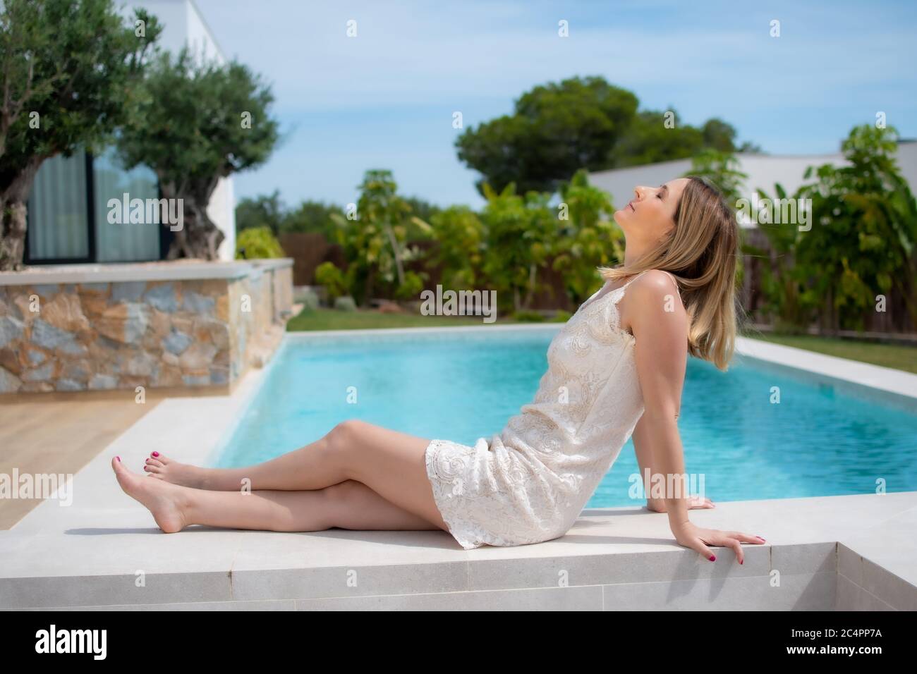 Bella donna giacente presso la piscina Foto Stock