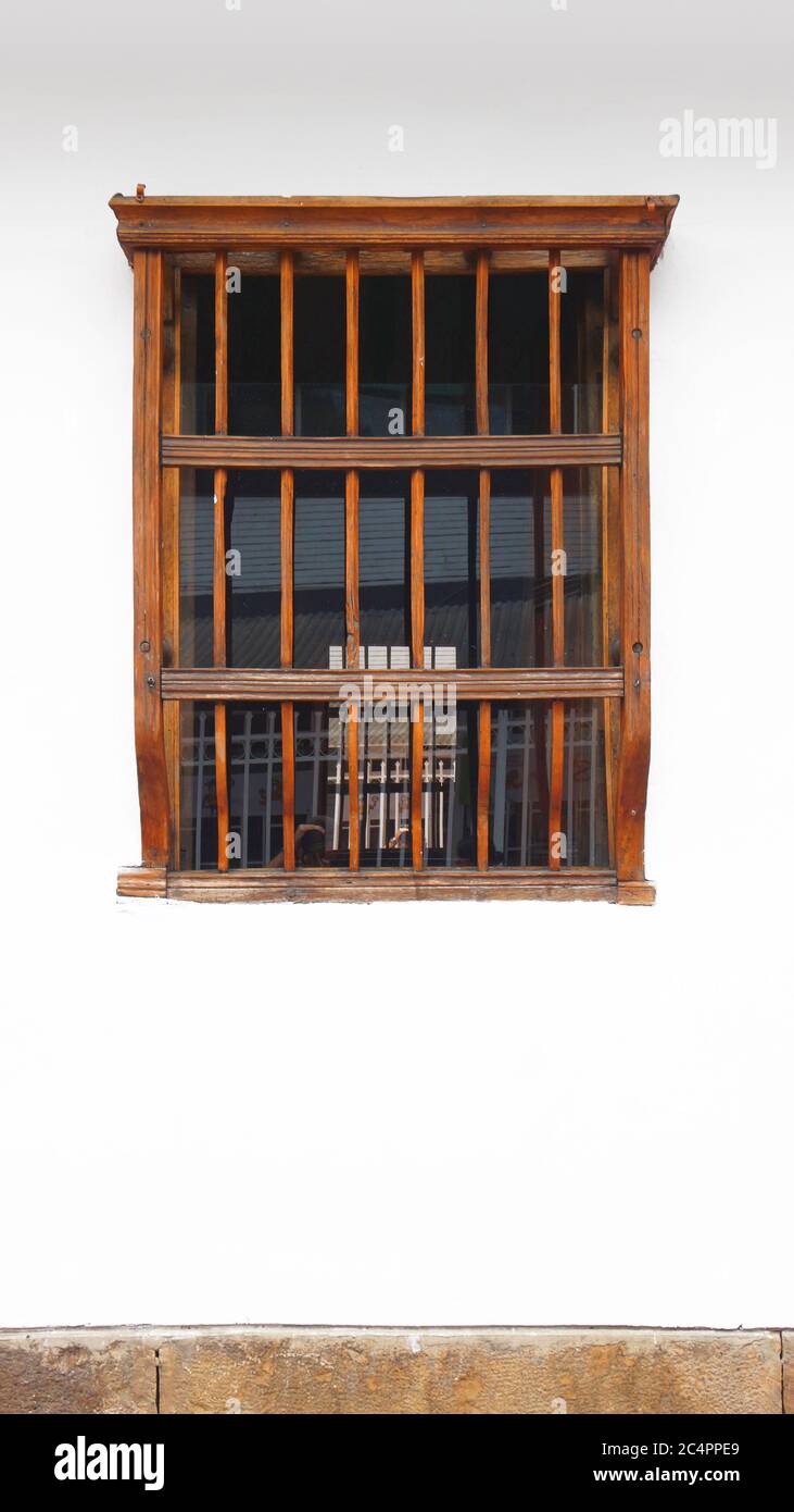Vecchia finestra di legno su parete bianca con bordo in pietra in formato verticale Foto Stock