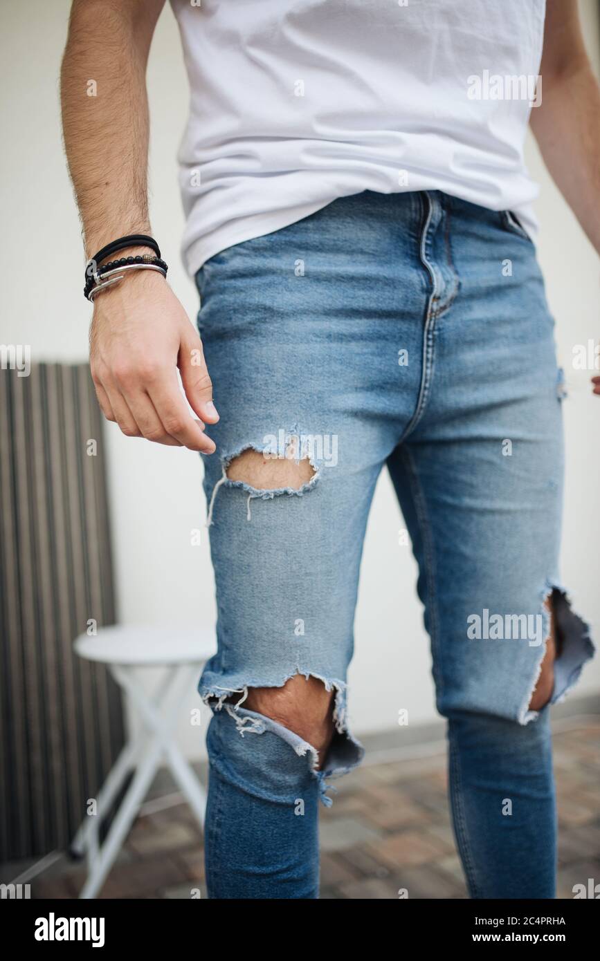 Immagine ravvicinata di un ragazzo attraente con jeans strappati Foto stock  - Alamy
