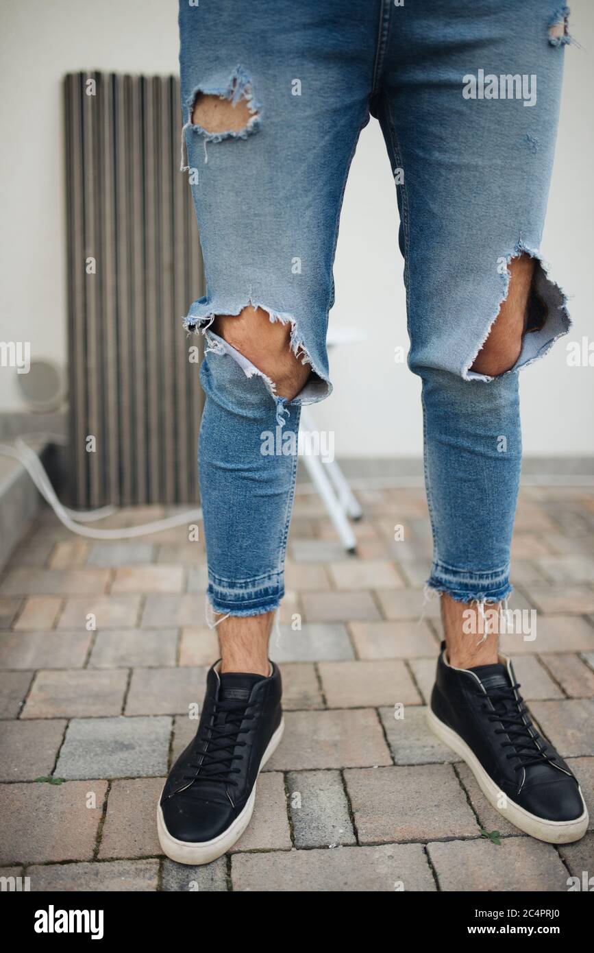 Immagine ravvicinata di un ragazzo attraente con jeans strappati Foto stock  - Alamy