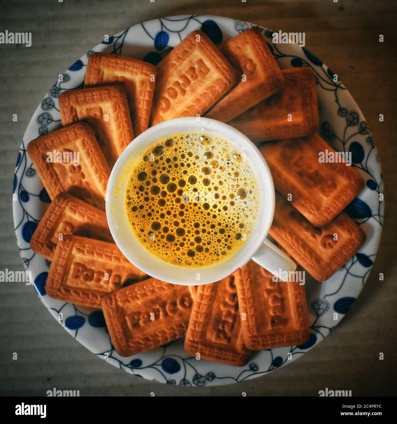 I biscotti di Parle si arrotolano intorno ad una tazza di tè con formazione di bolle in esso Foto Stock