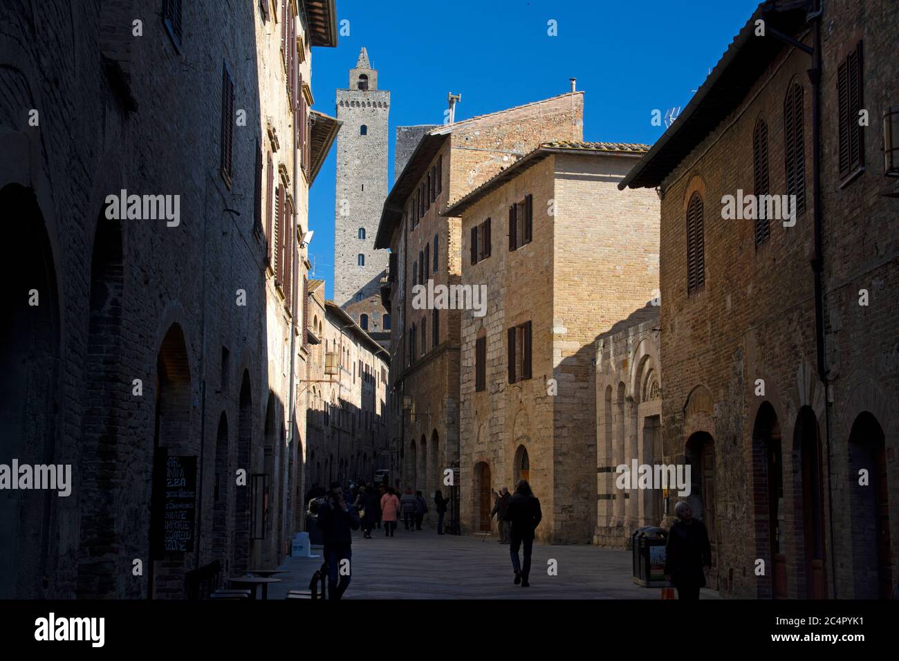 Strada stretta nella vecchia città toscana di San Gimignano, provincia di Siena, Toscana, Italia Foto Stock
