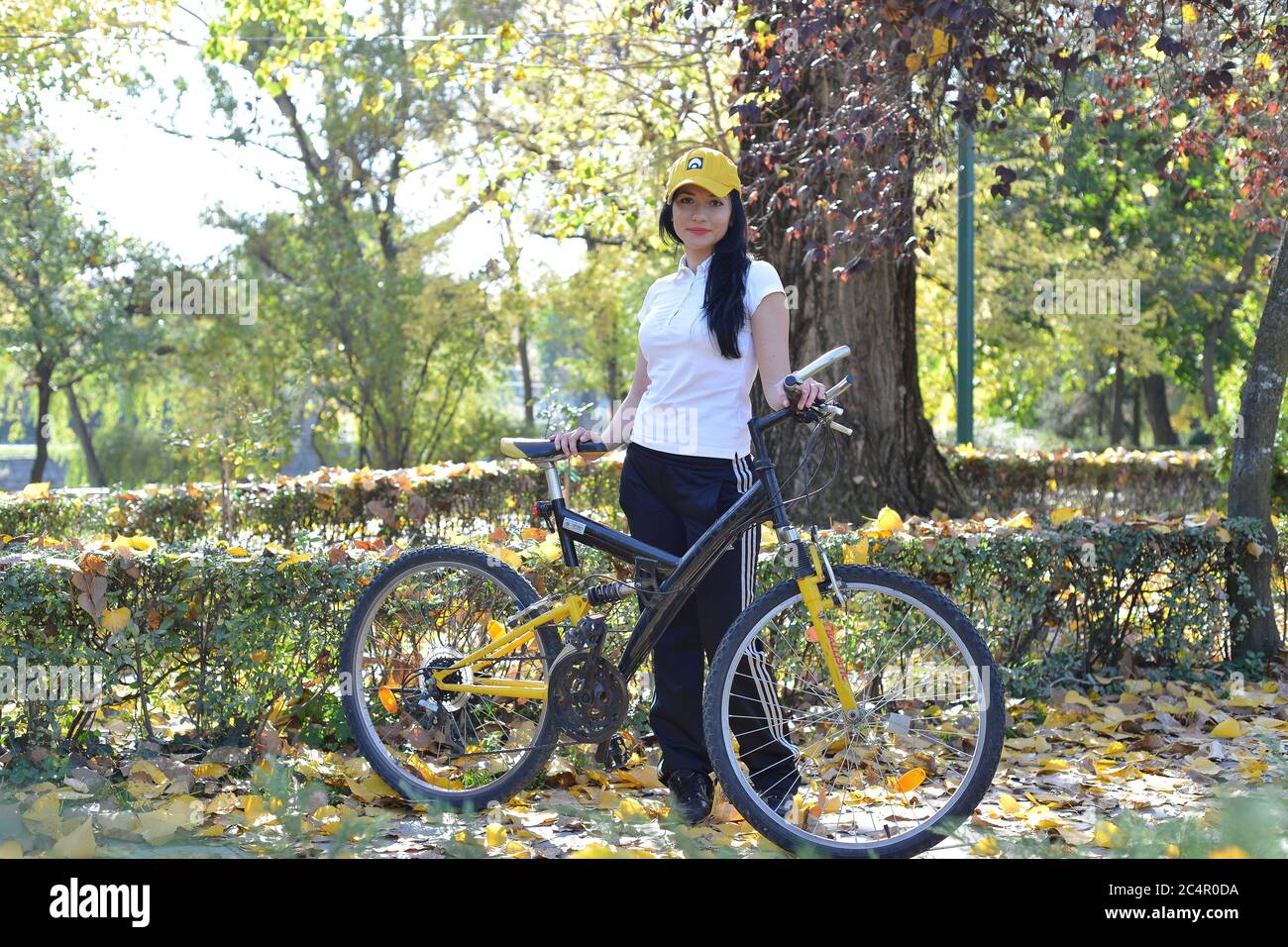 Ritratto di una giovane signora che cavalcava la bicicletta nel parco in un giorno d'autunno Foto Stock
