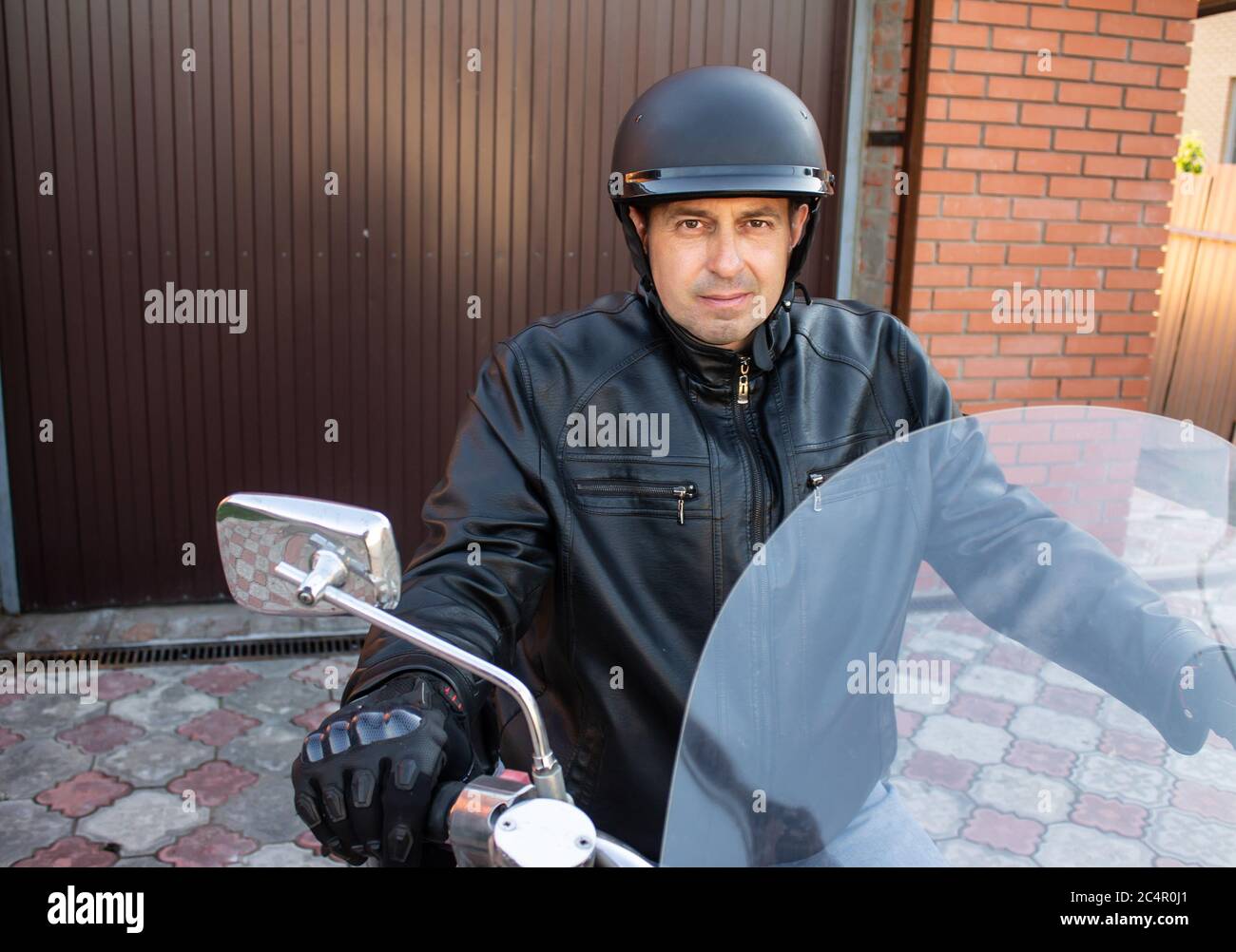 motociclista che indossa un casco, una giacca nera su un motociclo choppers Foto Stock
