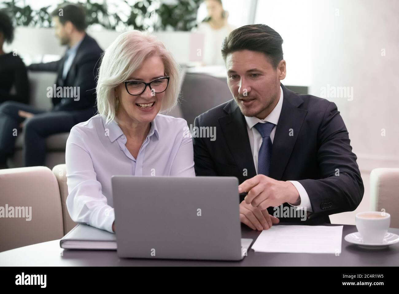Uomo d'affari e donna colleghi che guardano un notebook sorridente felice Foto Stock