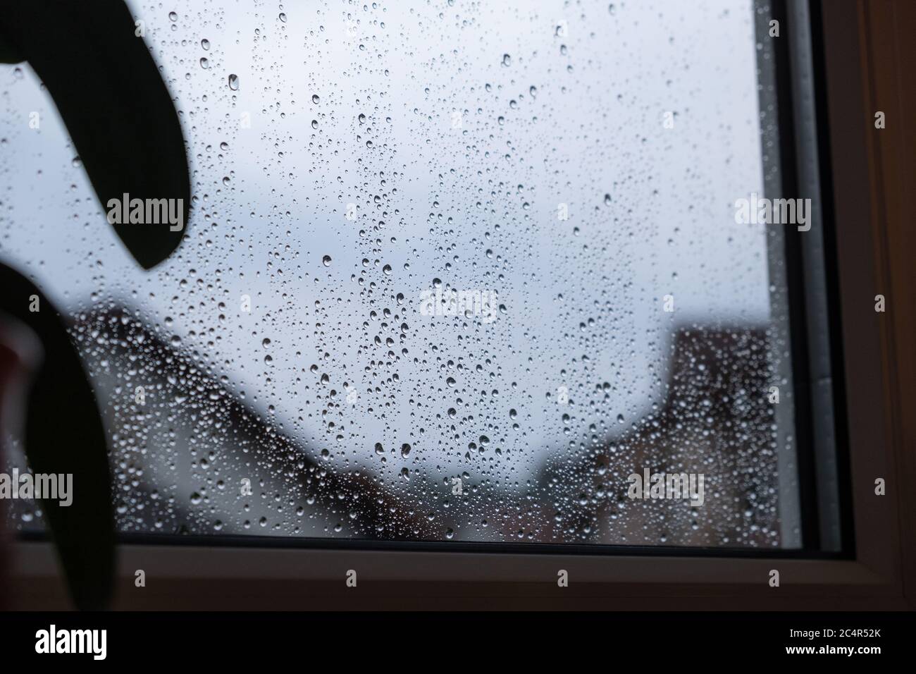 Tempo piovoso scuro con cieli grigi e un sacco di pioggia sul pannello della finestra. Foto Stock