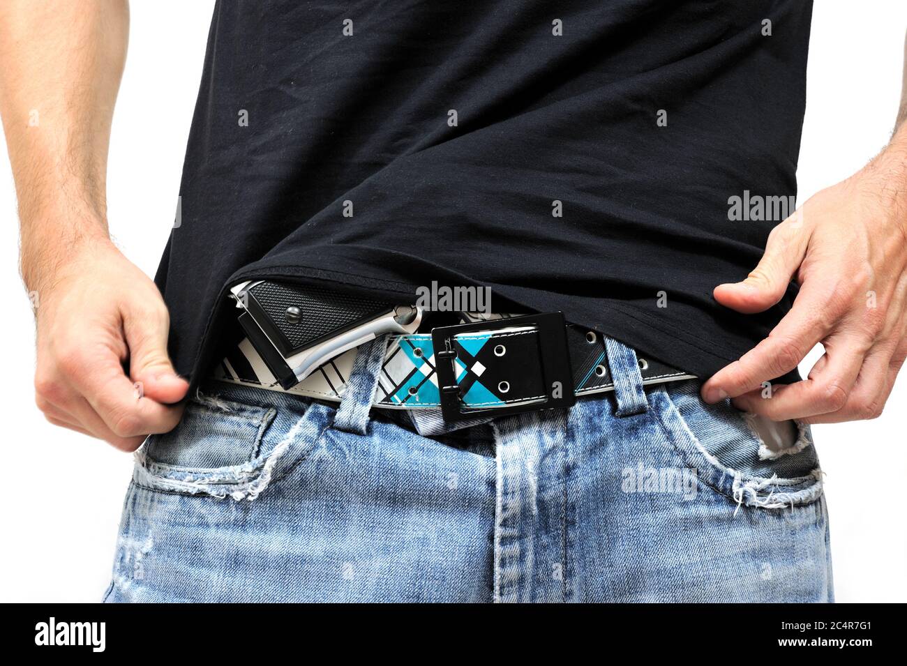 Uomo che nasconde una pistola infilata nei pantaloni Foto stock - Alamy