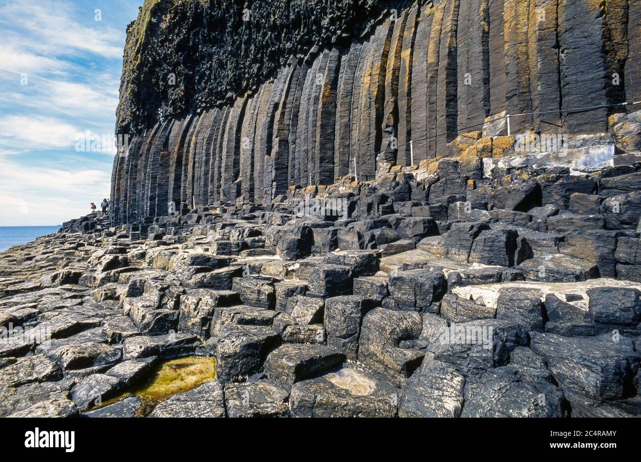 Visita passerella sotto le scogliere di mare in colonne di basalto esagonali, l'Isola di Staffa, Scozia, Regno Unito Foto Stock