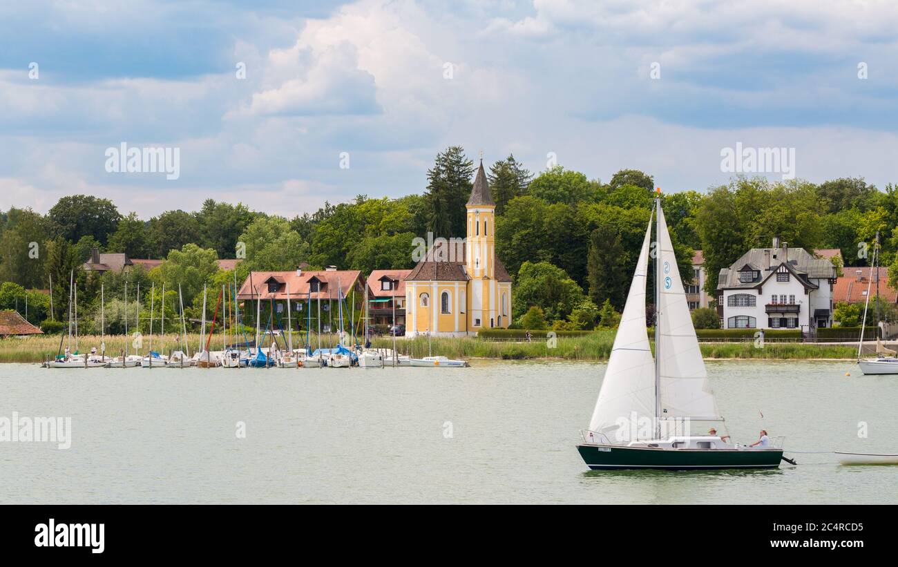 Barca a vela che naviga di fronte alla chiesa di San Alban. Panorama idilliaco del Lago Ammersee. Foto Stock