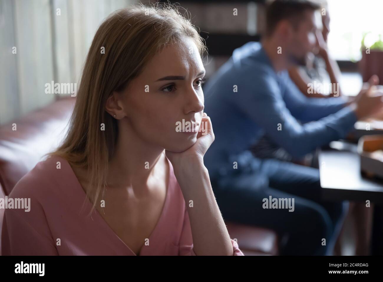 La ragazza sola si siede nel caffè aspettando il ragazzo si sente abbandonato Foto Stock
