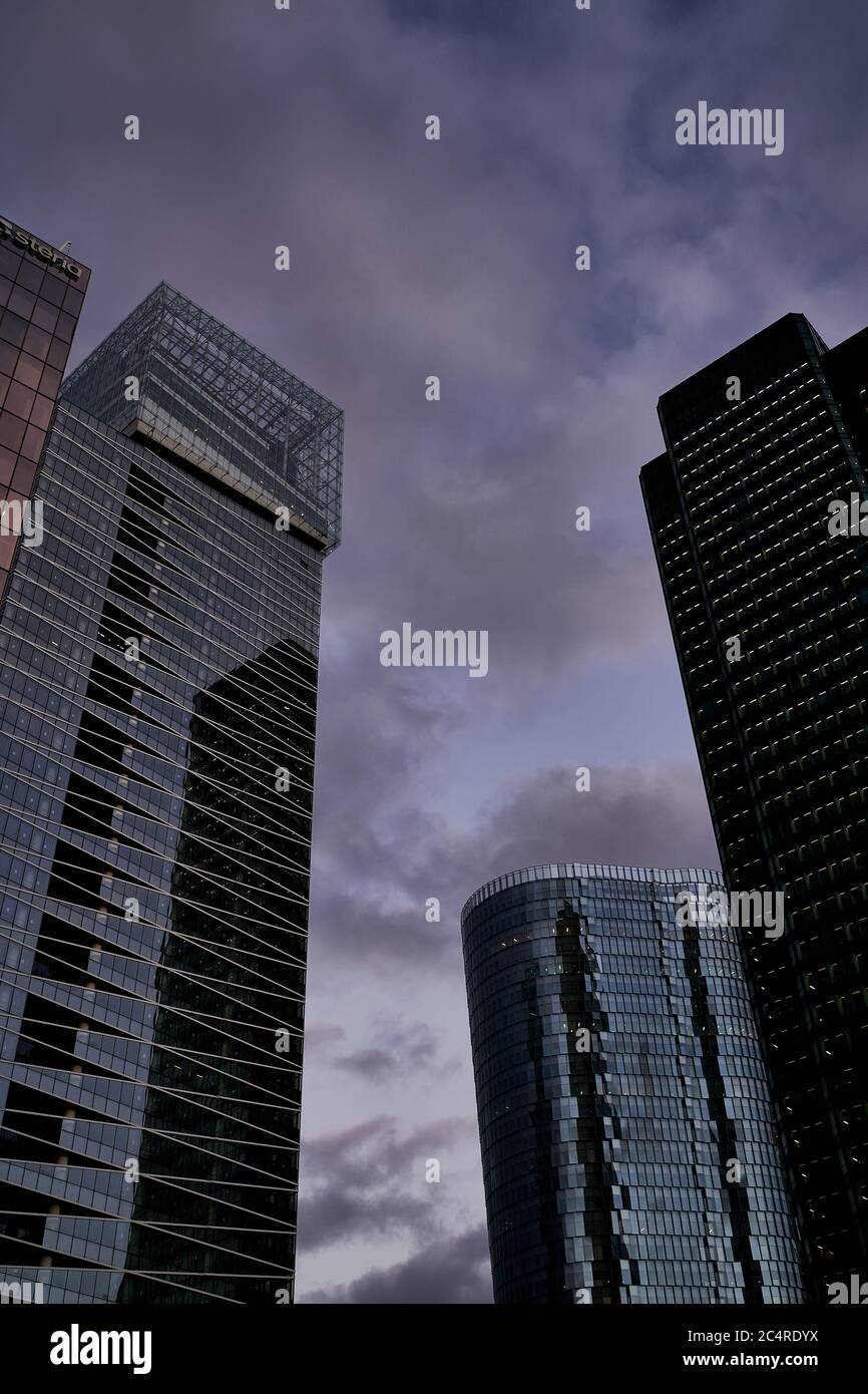 Torri per uffici e il arrotondato Cœur Défense si stagliano contro un cielo viola al crepuscolo, La Défense, Parigi Foto Stock