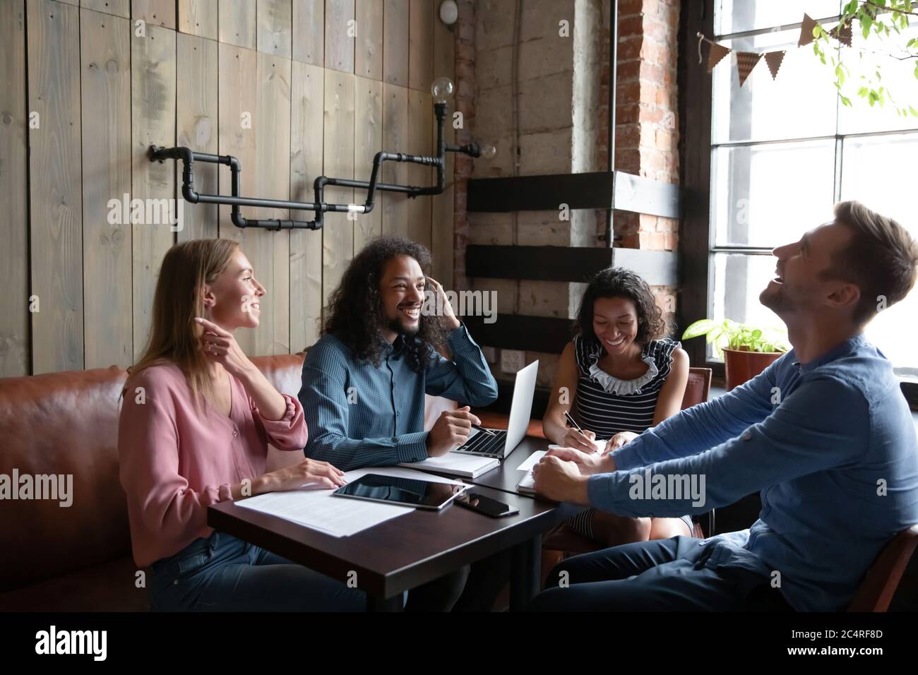I compagni di squadra che lavorano siedono al bar godono di una pausa divertente parlare Foto Stock
