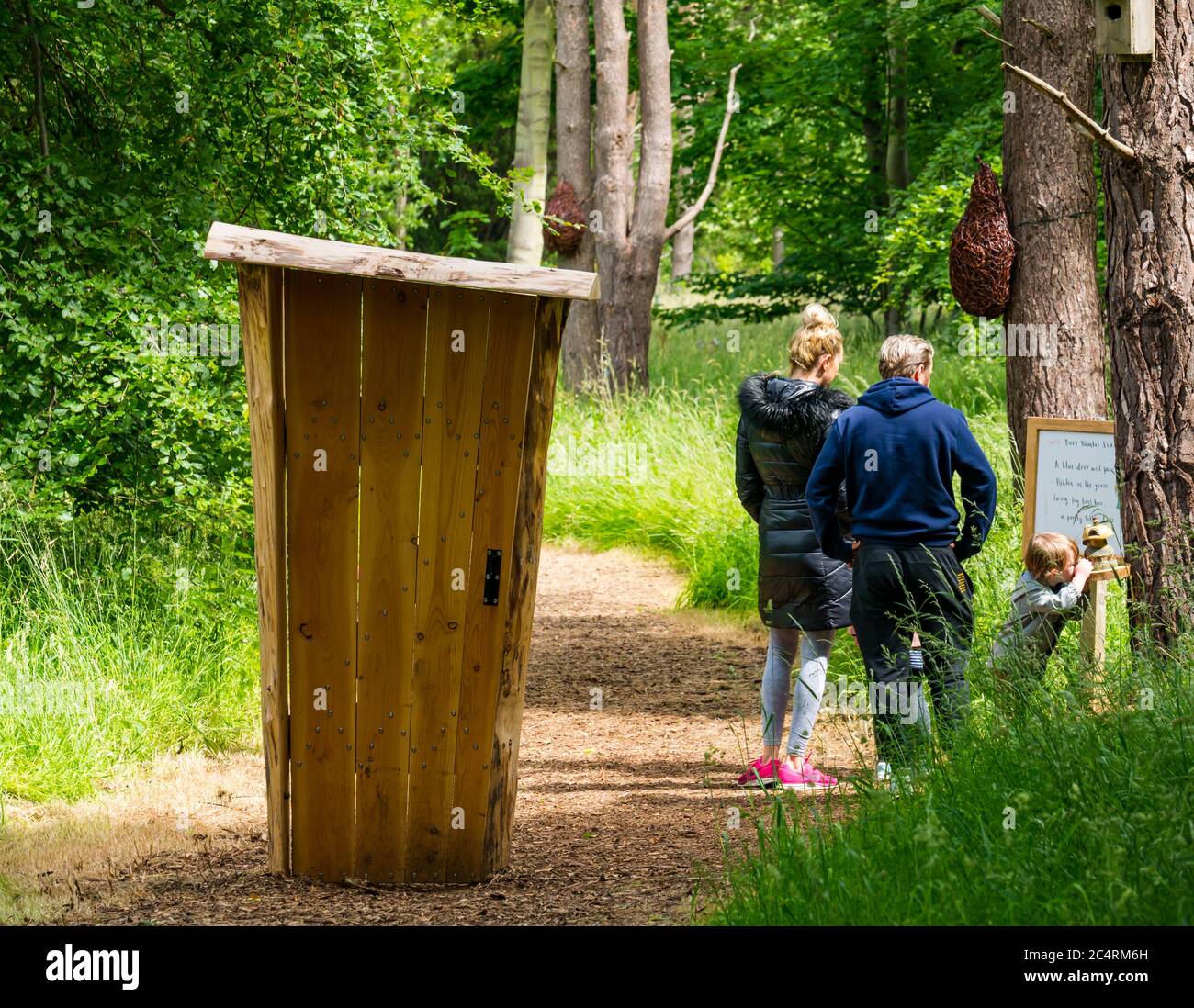 Una famiglia con bambini sulla pista delle fate con una porta solitaria, Archerfield Estate, East Lothian, Scozia, Regno Unito Foto Stock