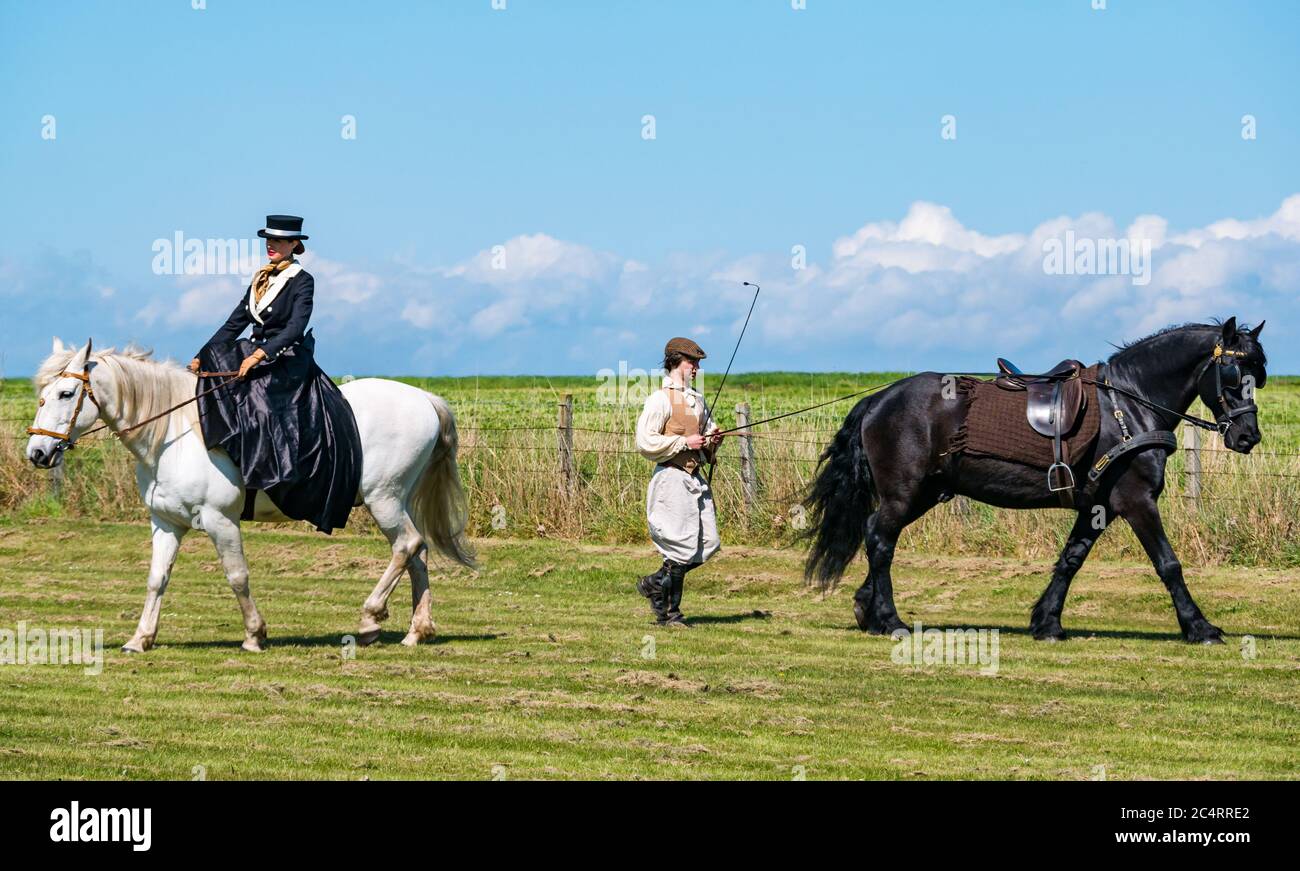 Squadra equestre Les Amis D'Onno: Donna in costume eduardiano equitazione e uomo con Clydesdale evento bellico, Fortune Est, Lothian Est, Scozia, Regno Unito Foto Stock