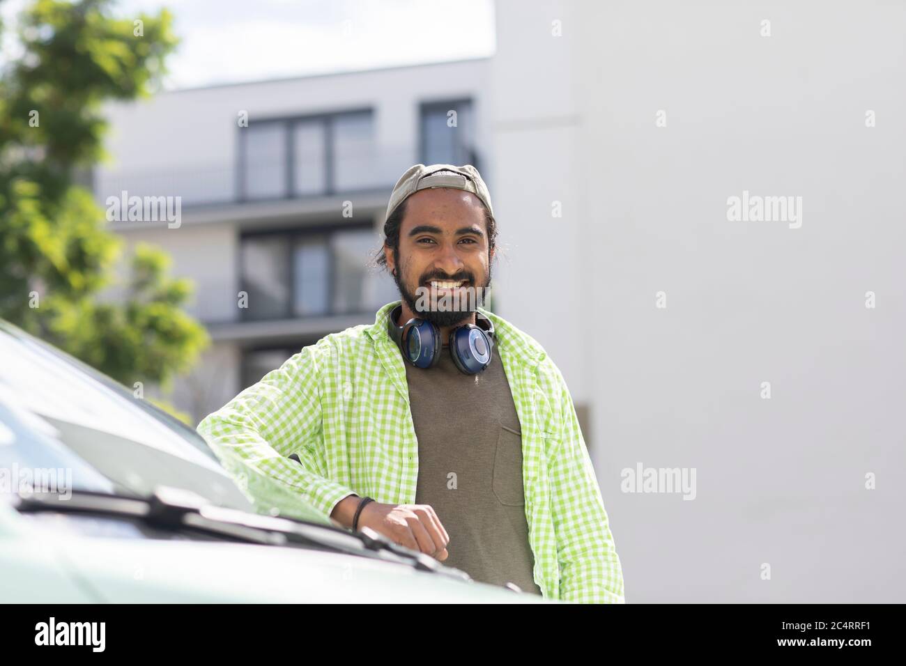 giovane uomo davanti a un'auto con cuffie Foto Stock