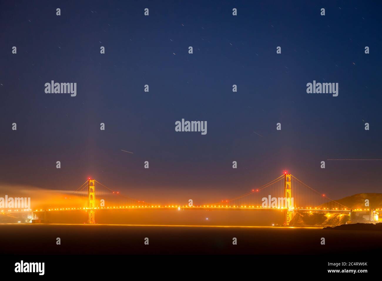 Il Golden Gate Bridge con nuvole e stelle di notte. Vista da Angel Island. Foto Stock