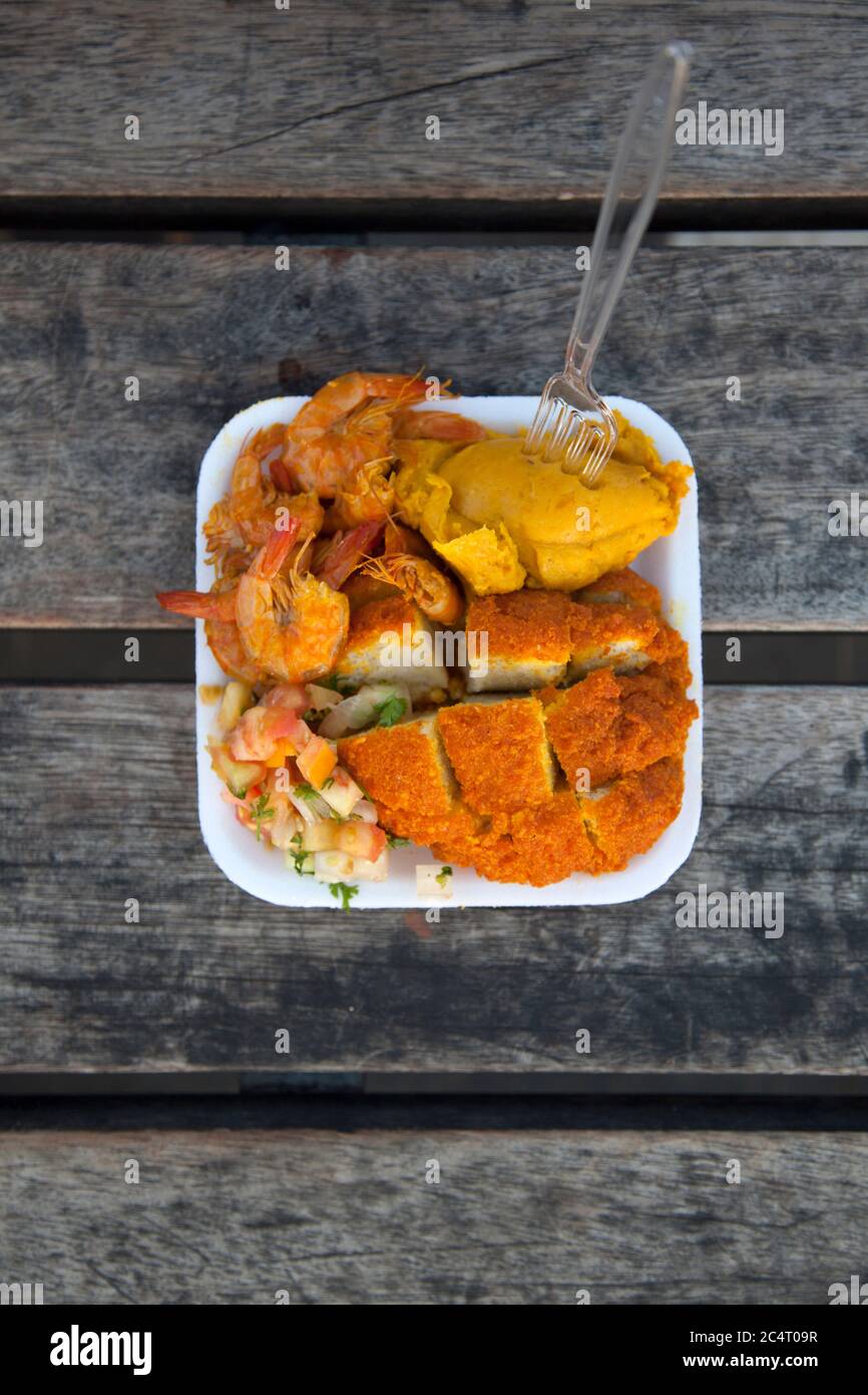 L'acarajé, un piatto venduto dai venditori ambulanti a Salvador de Bahia, Brasile, fatto di fagioli pelati e purè fritti in olio di dendê e spesso ripieni di gamberetti. Foto Stock