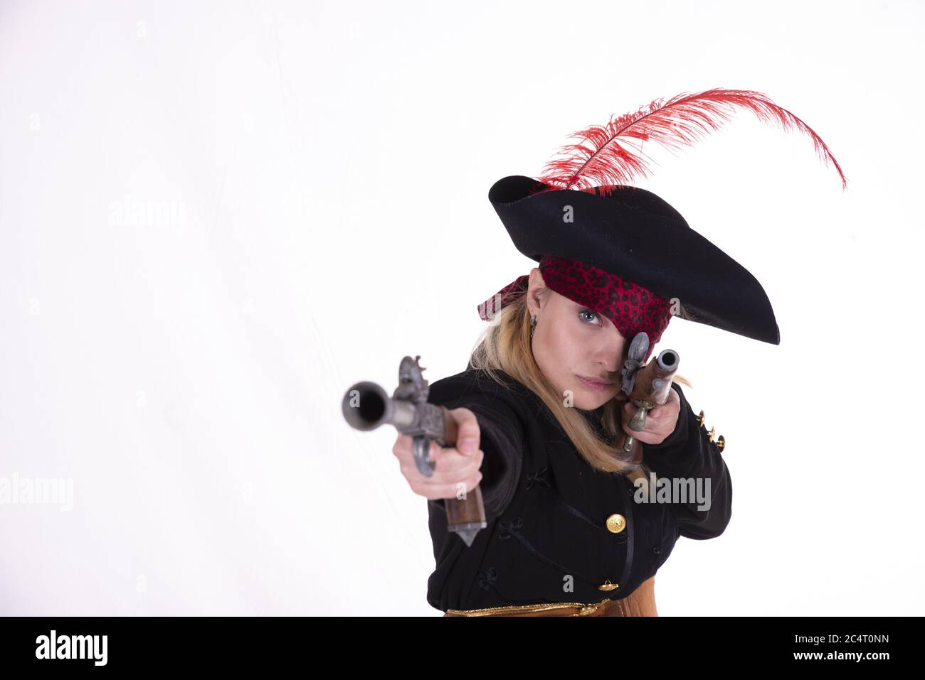 Donna in costume pirata che punta con due pistole Foto Stock