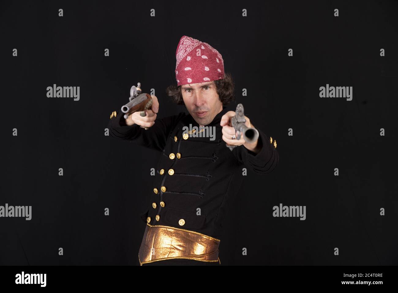 Maschio in costume pirata che punta con due pistole Foto Stock