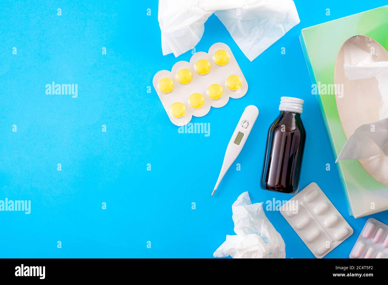 Giorno di malattia e congedo medico concetto con la posa piatta di sciroppo di tosse, termometro, lozenges mal di gola, bos di carta tessuti, pillole e farmaci isolati Foto Stock