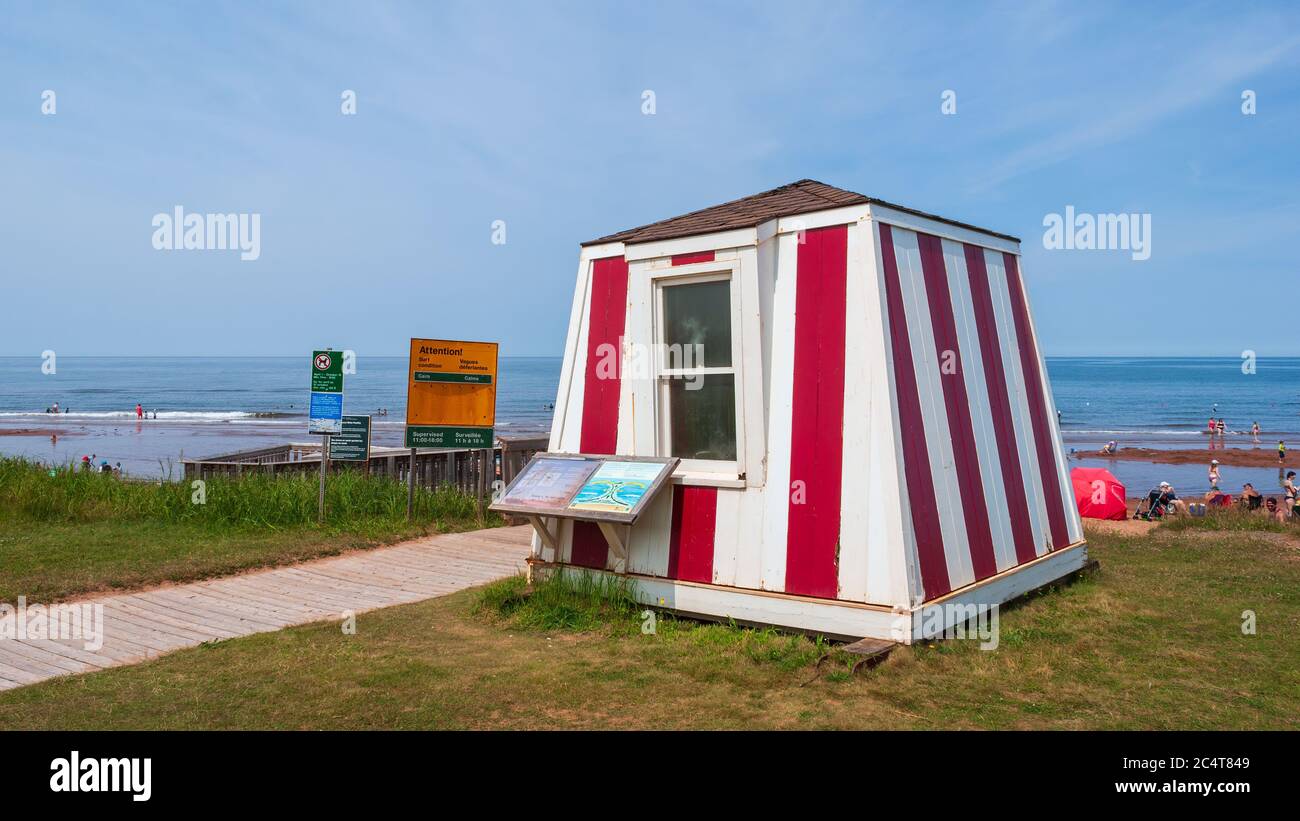 Stazione bagnino vicino ad una spiaggia trafficata. Passerella e cartelli di avvertimento. Cielo blu e acque calme. Stanhope Beach, Prince Edward Island National Park, Canada Foto Stock