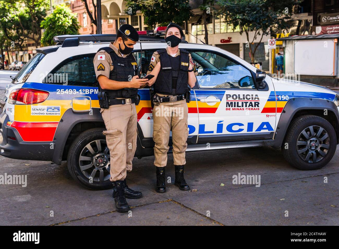 Gli ufficiali di polizia militare stanno assicurandosi che i cittadini brasiliani rispettino il mandato di blocco e le regole di allontanamento sociale nel centro di Belo Horizonte, Brasile. Foto Stock