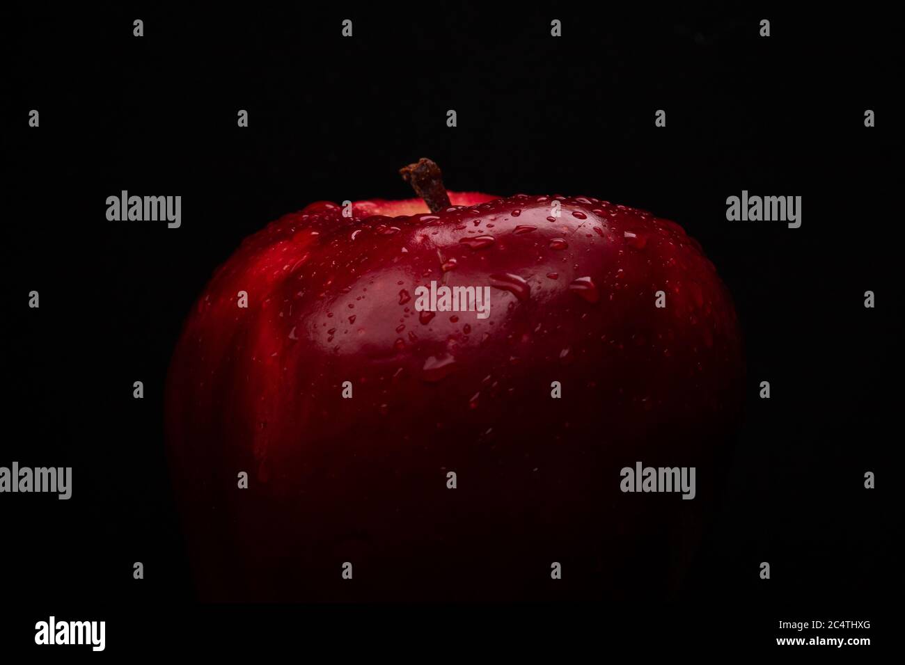Immagine ravvicinata scura di mela con gocce d'acqua Foto Stock