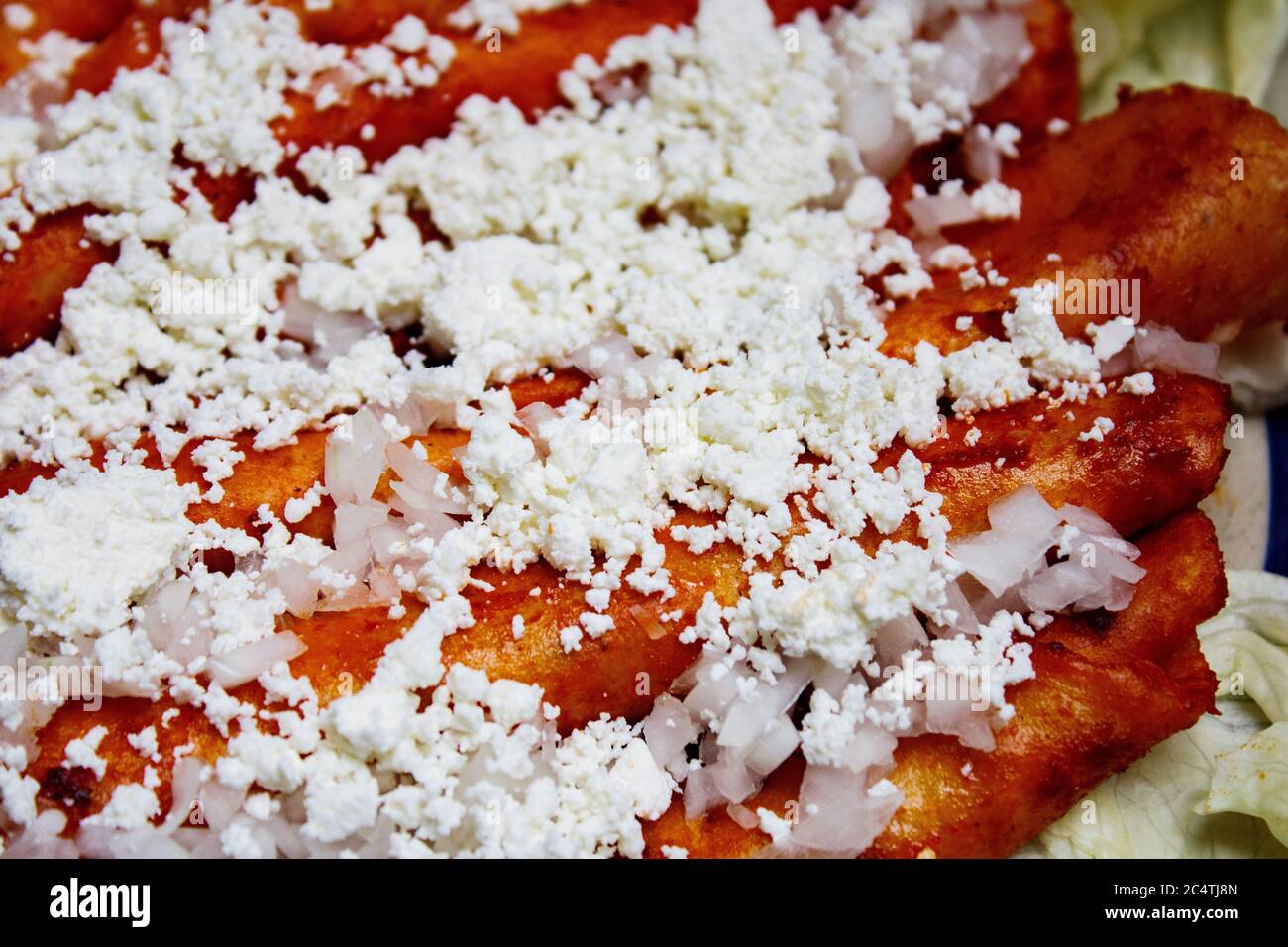 Piatto messicano tradizionale Enchiladas con patate al formaggio lattuga  crema cipolle e carote Foto stock - Alamy