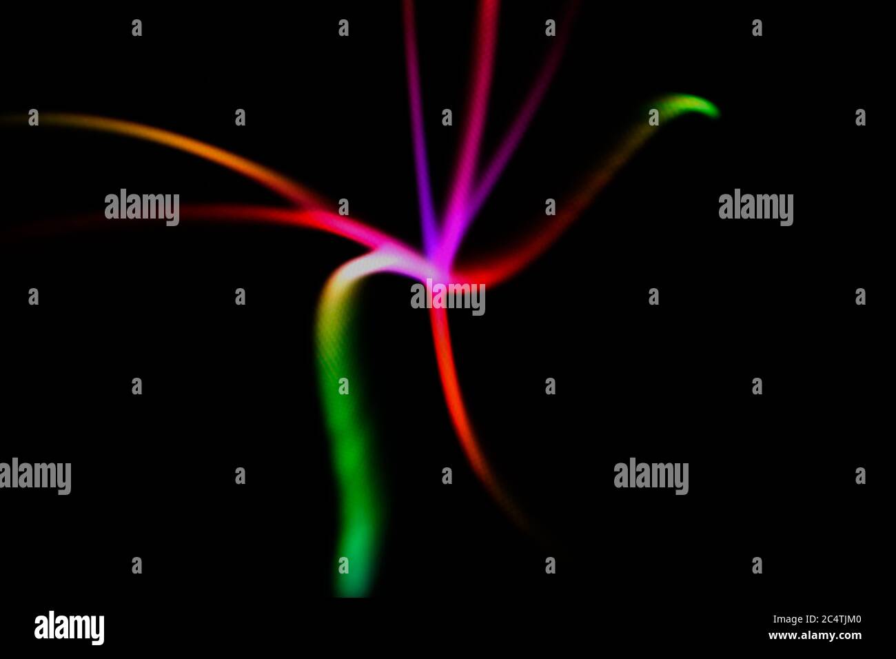 Incandescente neon linee su uno sfondo nero. Multicolor a forma di stella linee sfocati. Sfocato sfondo astratto. Foto Stock