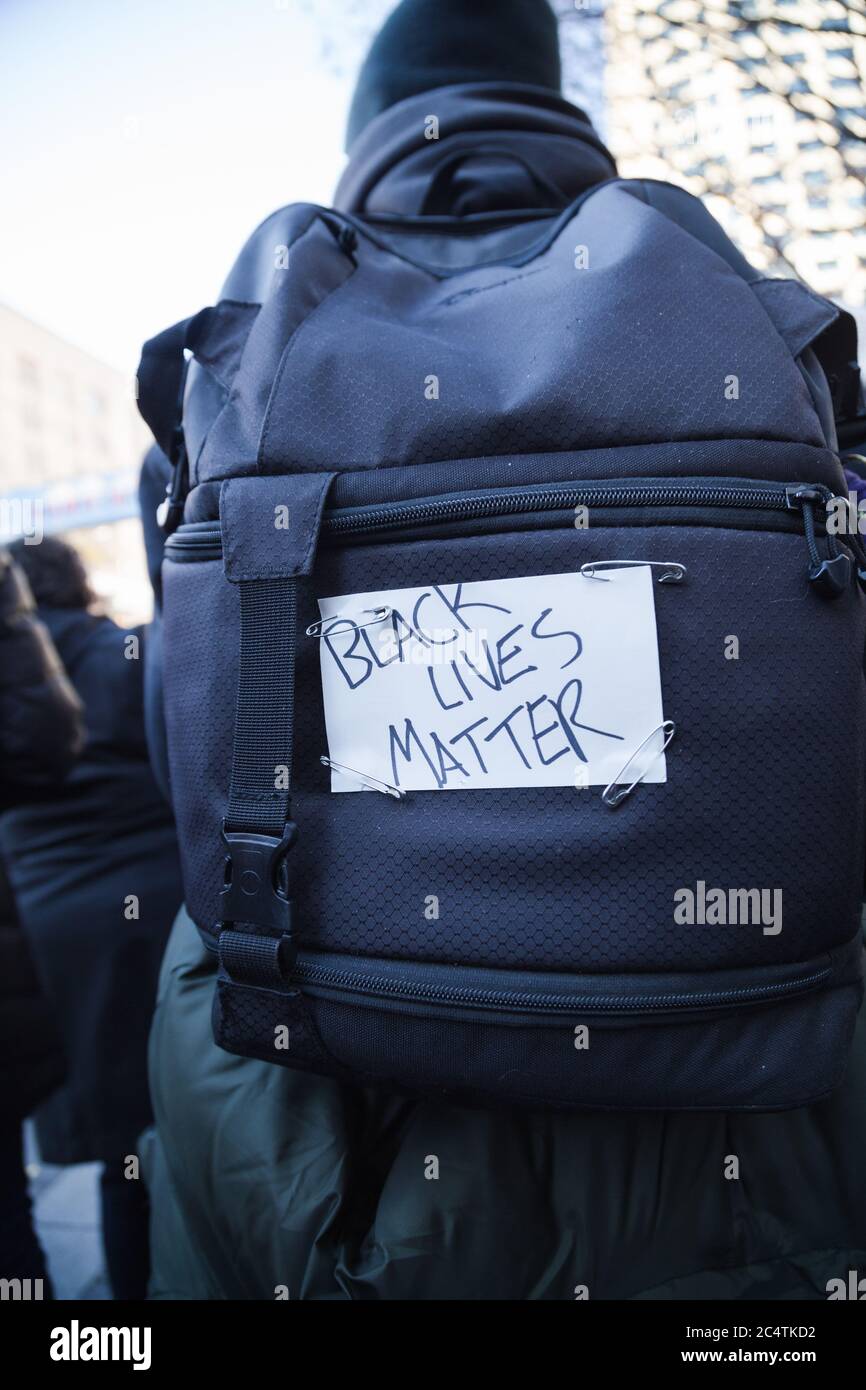 Seattle, Stati Uniti. 27 Novembre 2015. Un uomo cammina al rally BLM con un cartello scritto a mano Black Lives Matter agganciato al suo zaino. Foto Stock