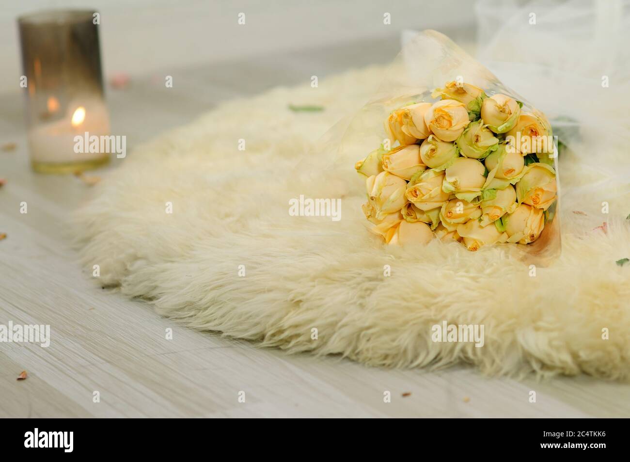 Un bouquet di boccioli di rosa gialla freschi su un Rug Foto Stock