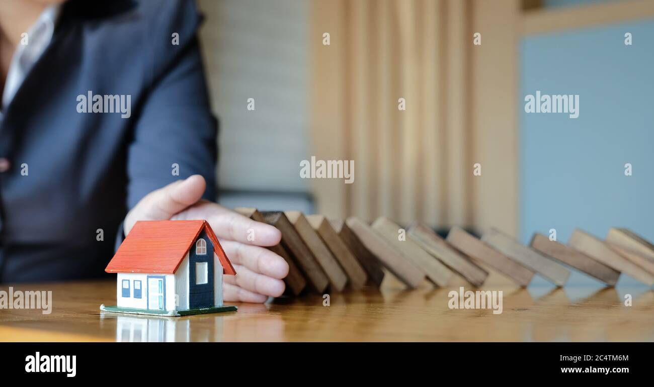 Proteggere la casa da caduta sopra i blocchi di legno, assicurazione e concetto di rischio. Foto Stock