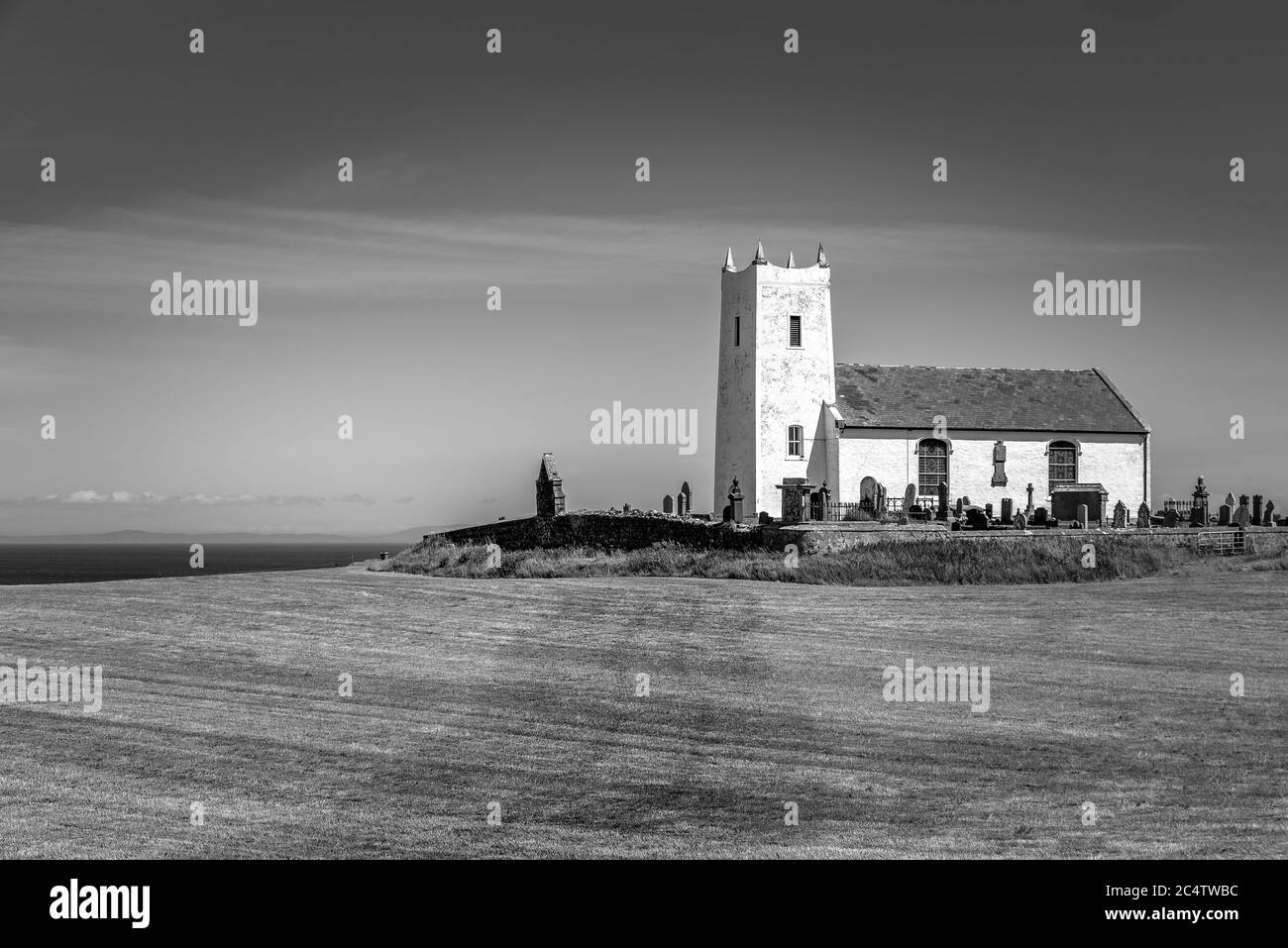 Ballintoy, Irlanda del Nord - 20 giu 2020: La vecchia chiesa di Ballintoy dell'Irlanda sulla costa di Antrim, nell'Irlanda del Nord, circondata da un vecchio grav Foto Stock