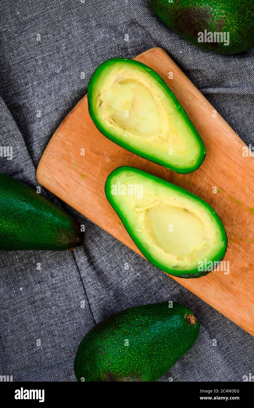 Avocado su un tagliere di legno. Avocado, verdure, cibo, biologico, verde, vegetariano Foto Stock