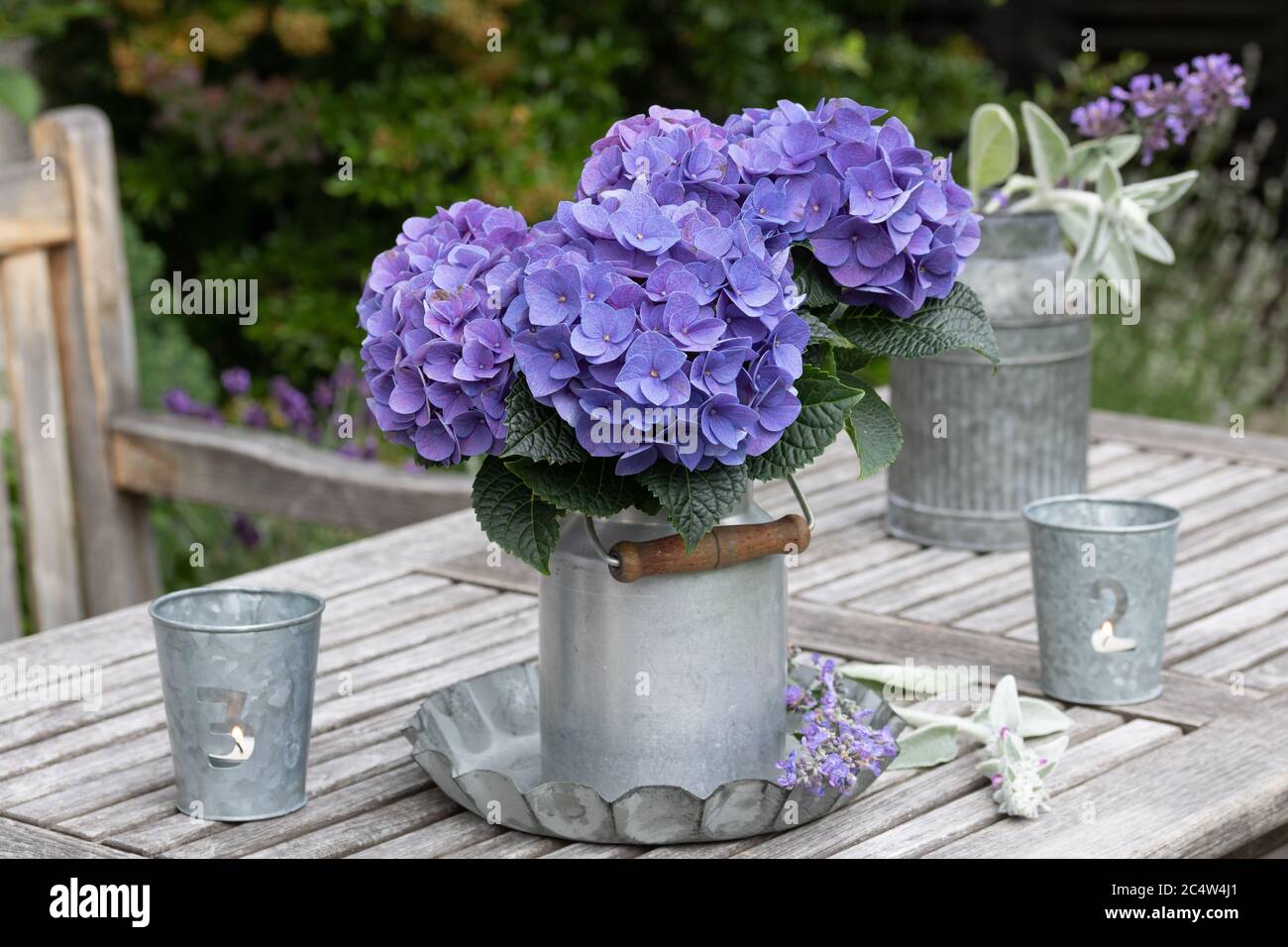 decorazione giardino d'epoca con idrangea in blu e lanterna da tavolo Foto Stock