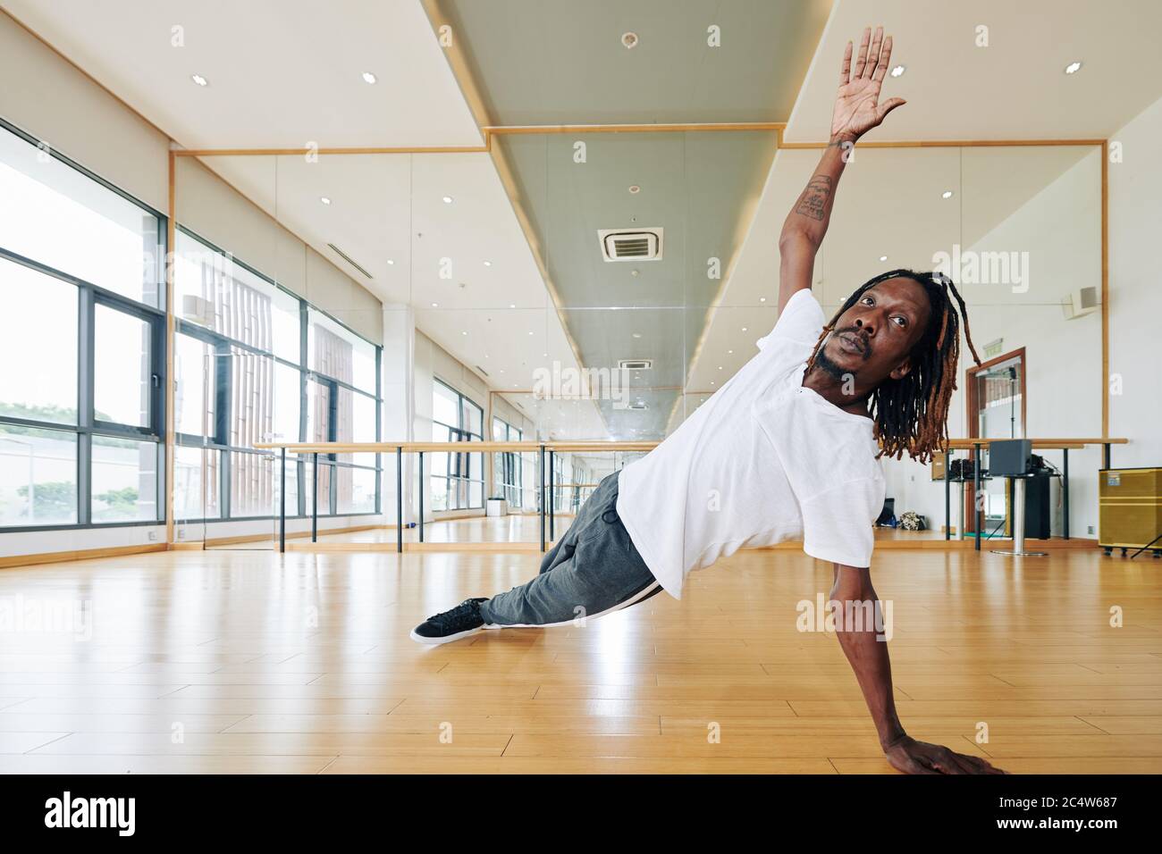 Ballerina di talento con dreadlock allenarsi in studio e fare fianco come parte della danza contemporanea Foto Stock