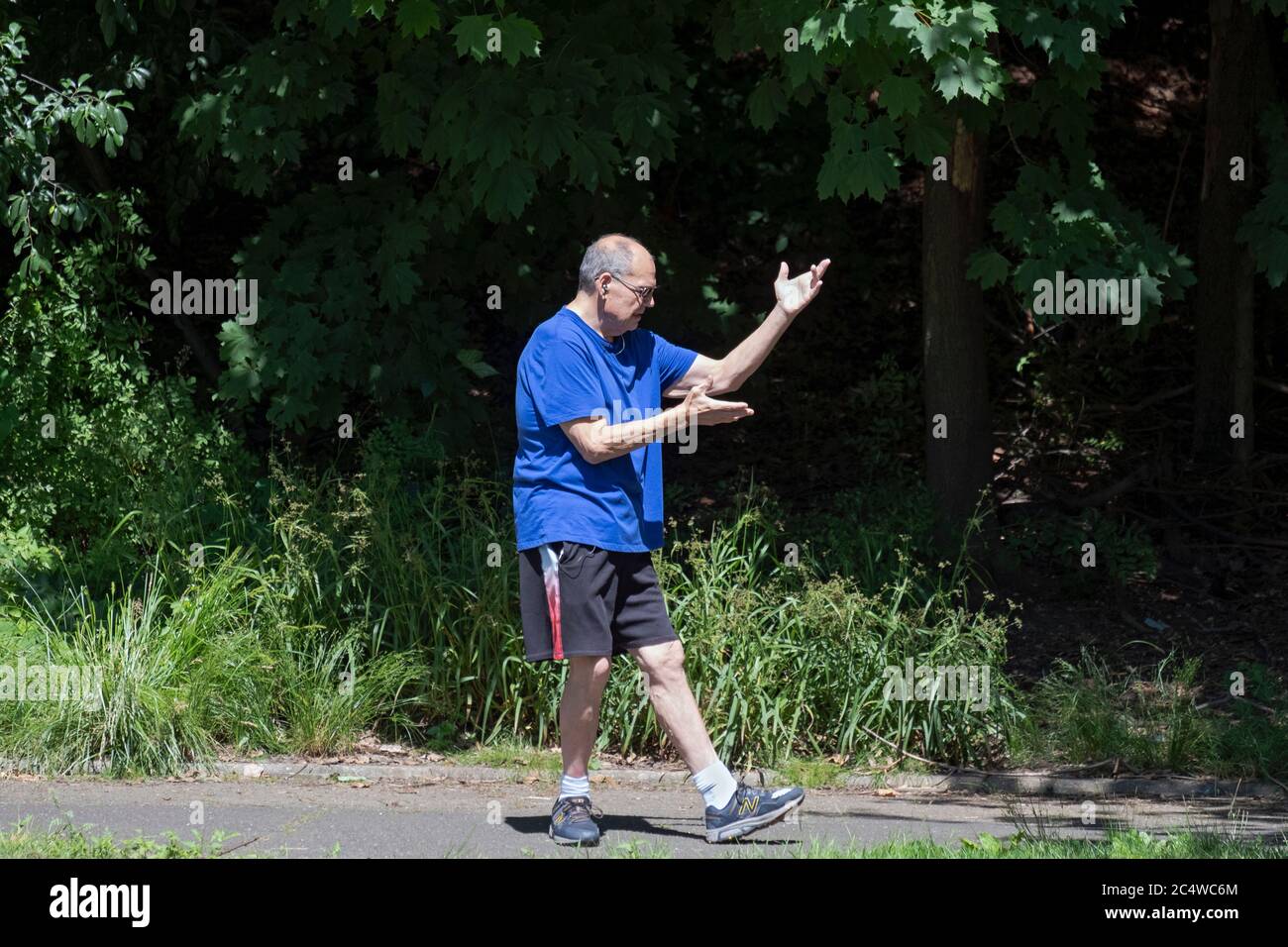 Un uomo anziano fa esercizi di Tai Chi nel Parco di Kissena a Flushing, Queens, New York City. Foto Stock