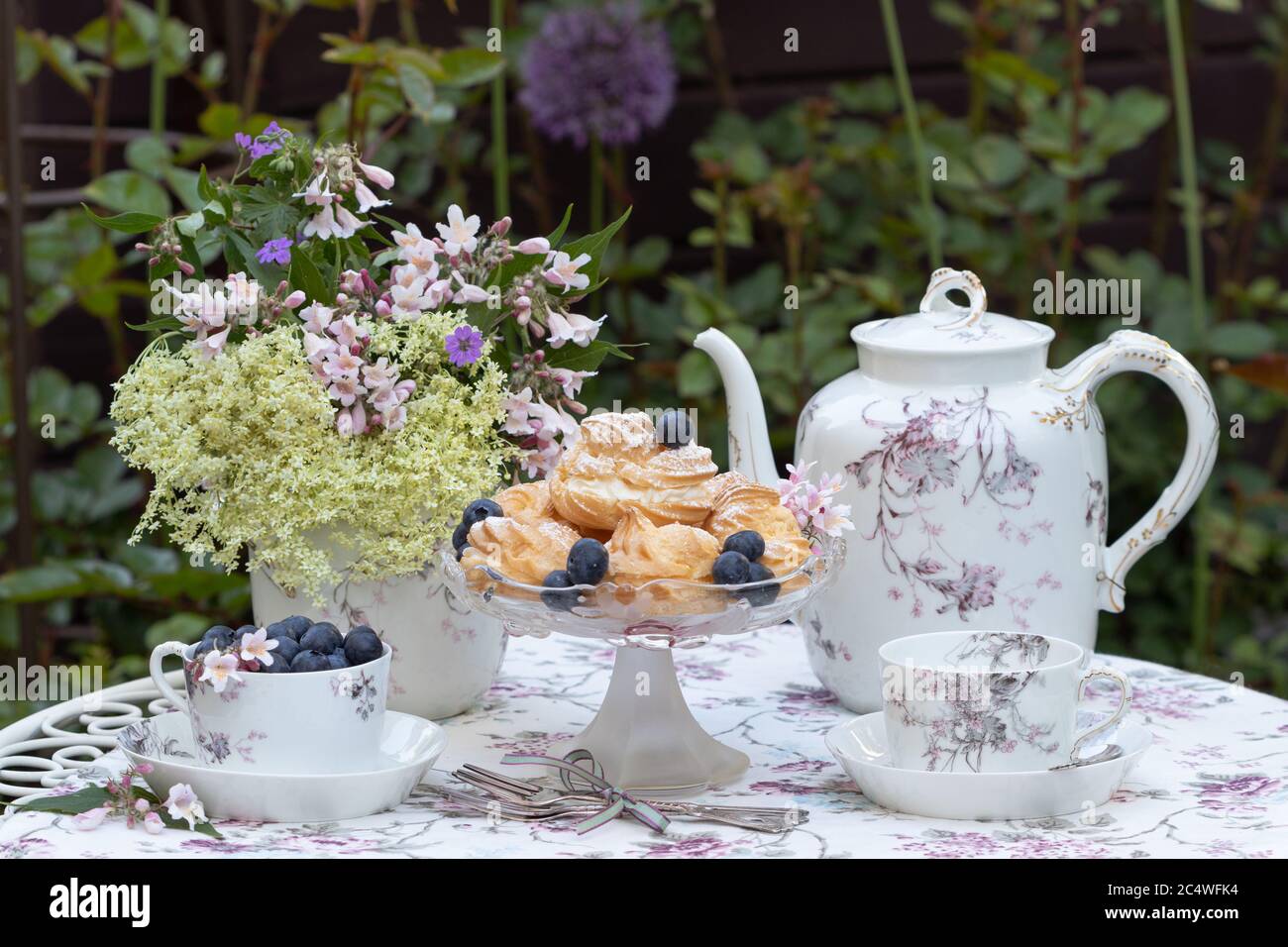 decorazione da tavolo con boccali di crema, mirtilli e porcellana d'epoca Foto Stock