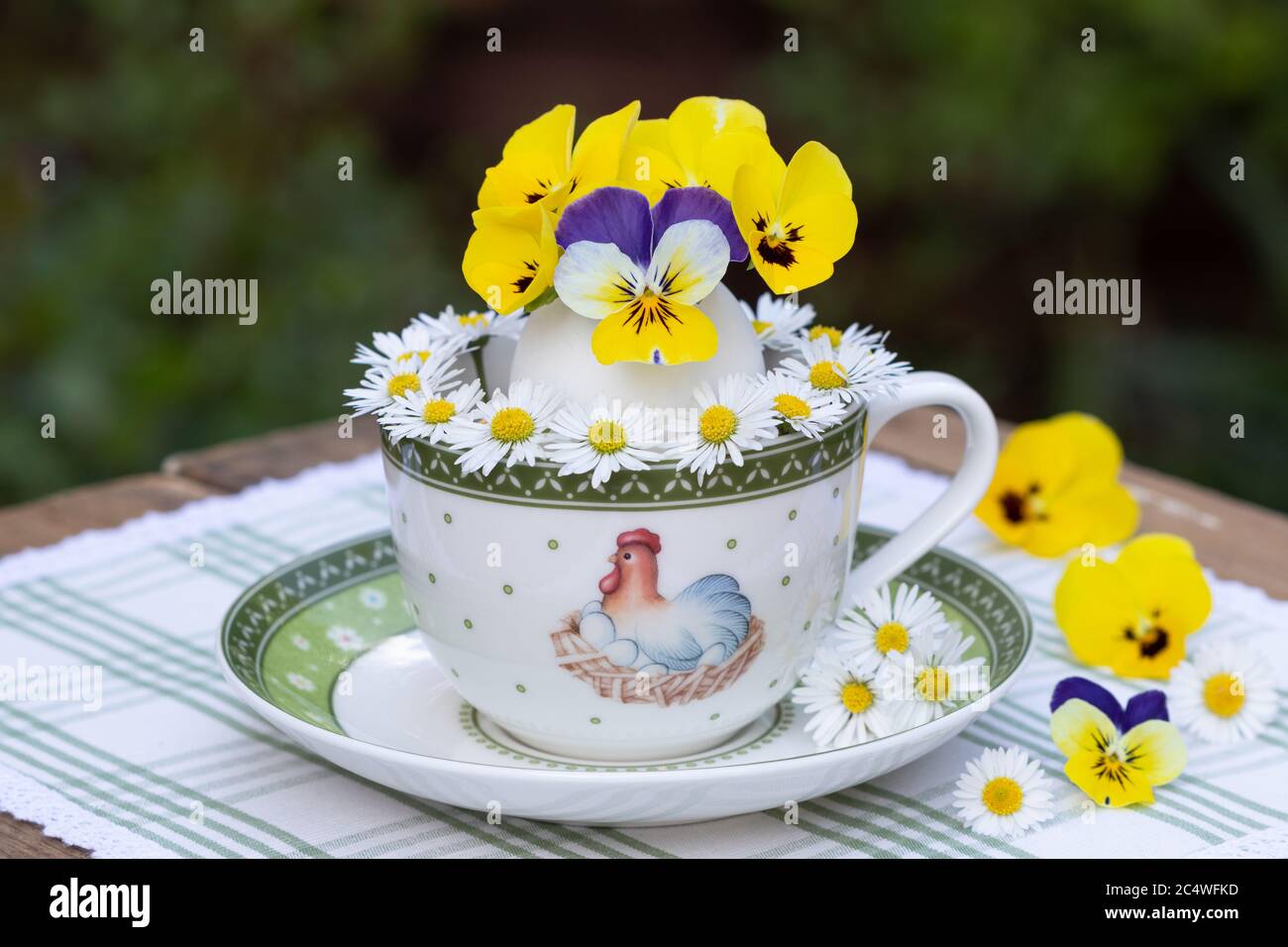 decorazione pasquale con fiori di viola e margherite in uovo Foto Stock