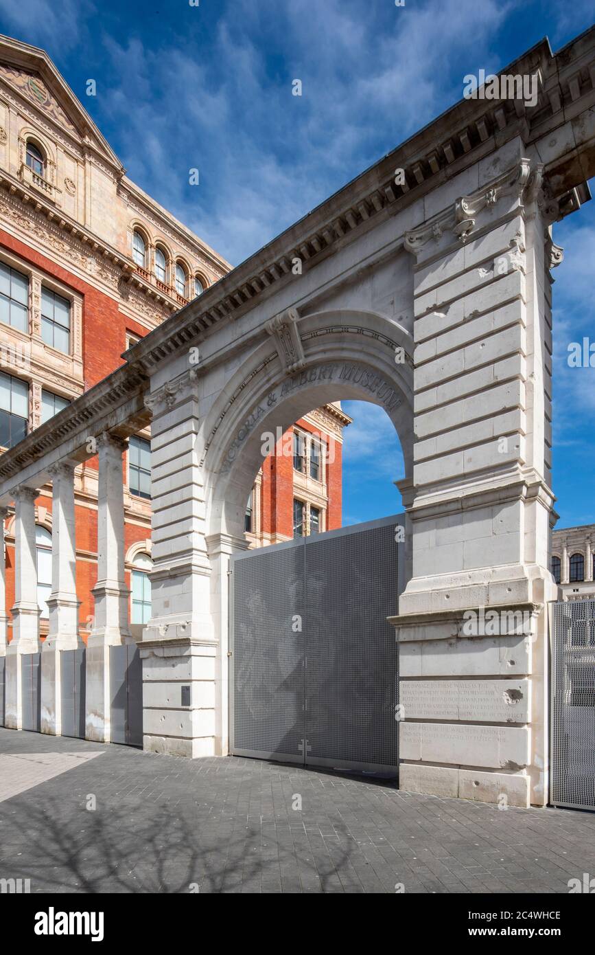 Vista obliqua dello schermo che mostra danni alle bombe e scritte di David Kindersley. Sackler Courtyard Gate, Victoria & Albert Museum, Londra, Regno Unito Foto Stock