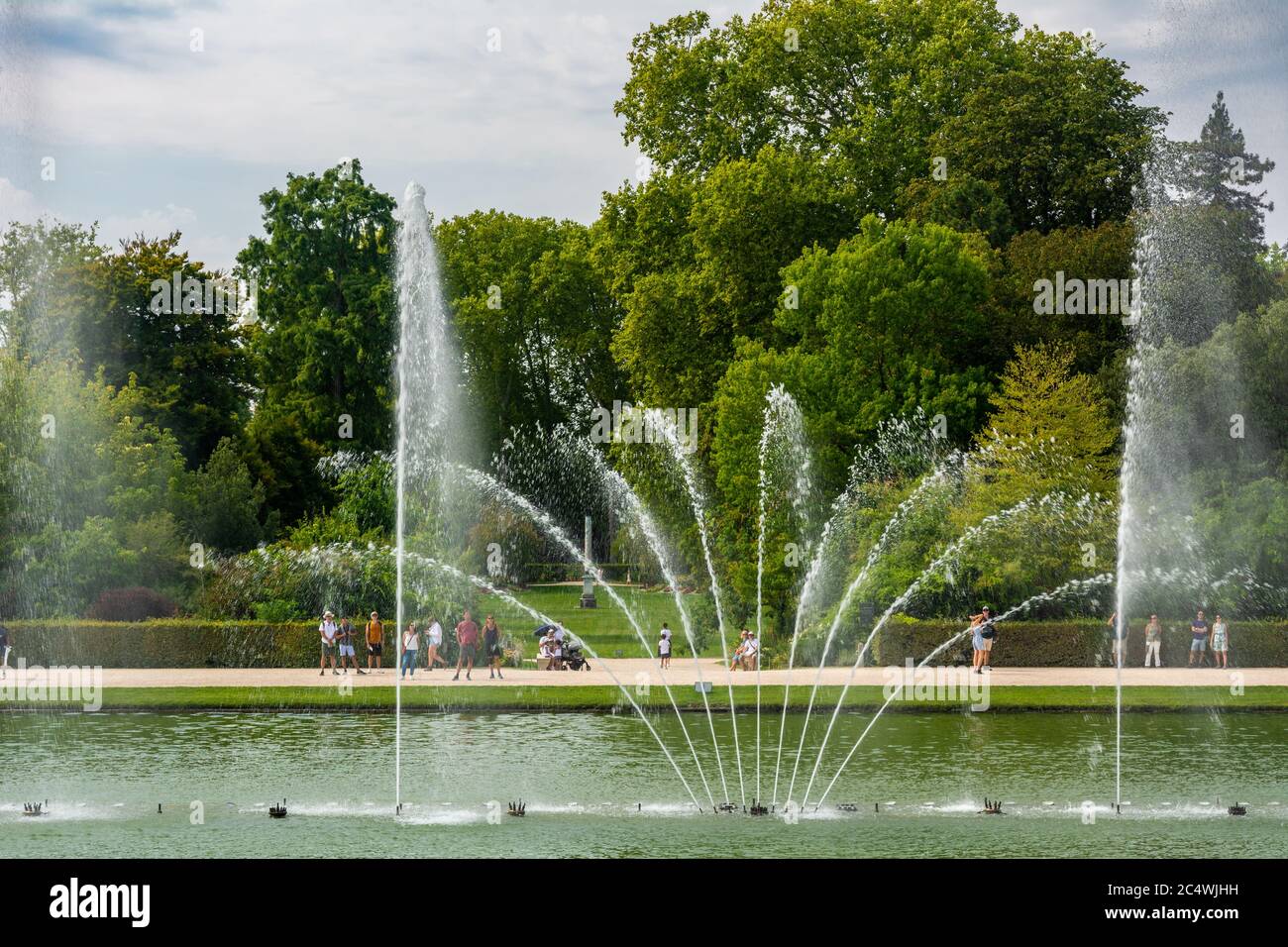 Versailles, Francia - 27 agosto 2019 : persone che guardano l'acqua che danzano alla fontana di specchio nel giardino del palazzo di Versailles Foto Stock