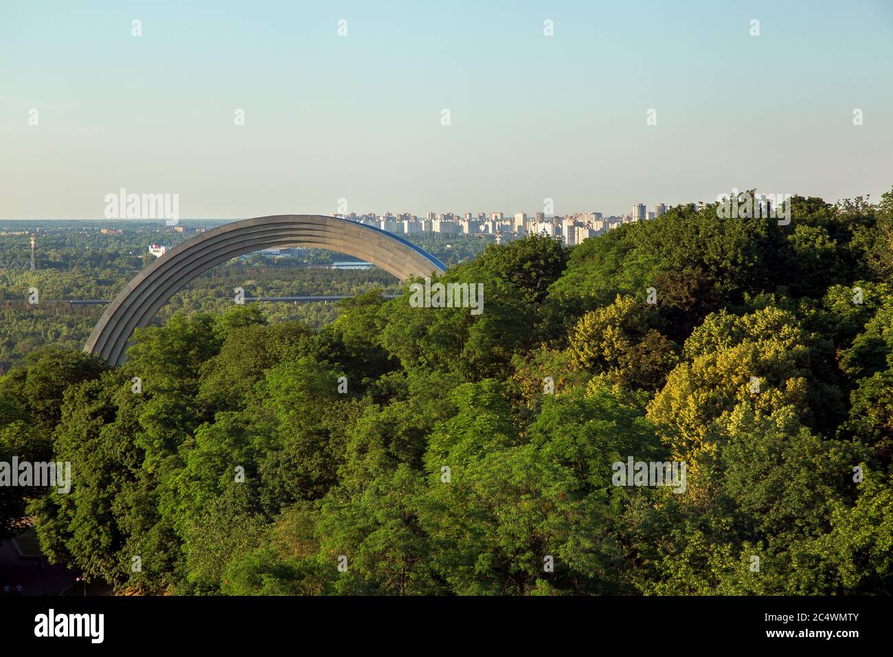 KIEV, UCRAINA - 4 giugno 2018: Monumento alla riunificazione dei popoli dell'Arcobaleno tra gli alberi verdi, vista dall'alto sul paesaggio urbano Foto Stock