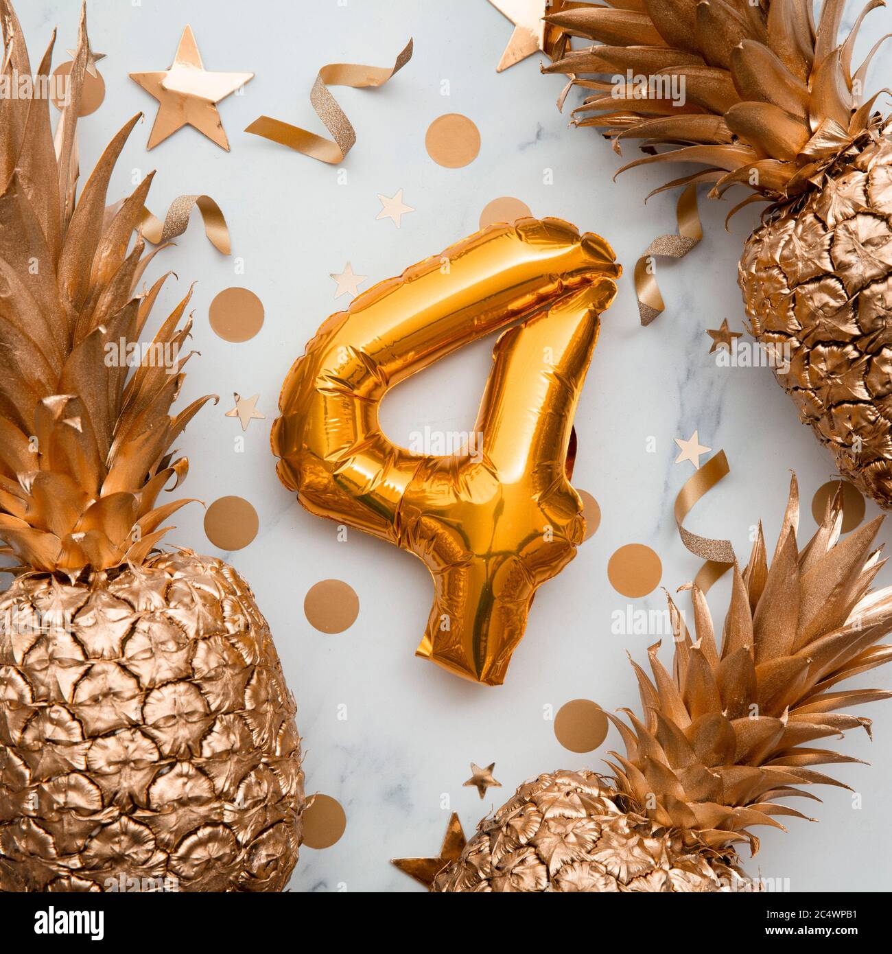 4° compleanno carta celebrazione con palloncini d'oro e ananas dorati Foto Stock