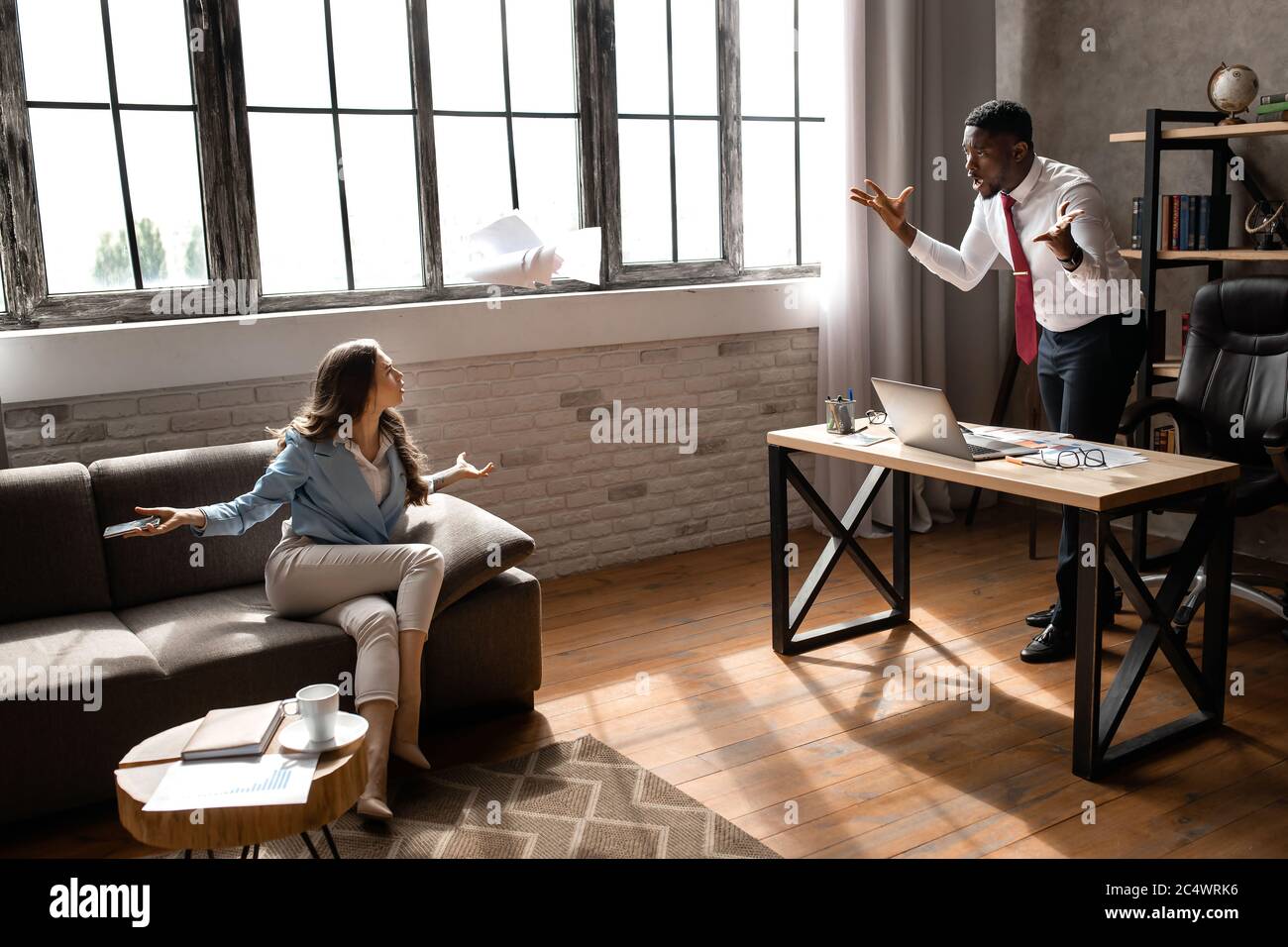 I partner che discutono sul posto di lavoro, non sono d'accordo con il documento. Foto Stock